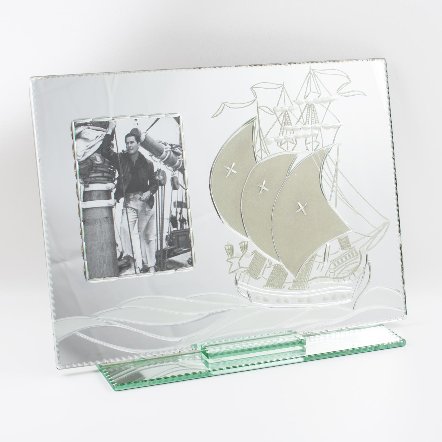Este impresionante marco de fotos de cristal de espejo plateado de gran tamaño de la década de 1940 presenta una base independiente de cristal de espejo con biselado alrededor que sostiene una lámina de cristal de espejo con un galeón velero antiguo