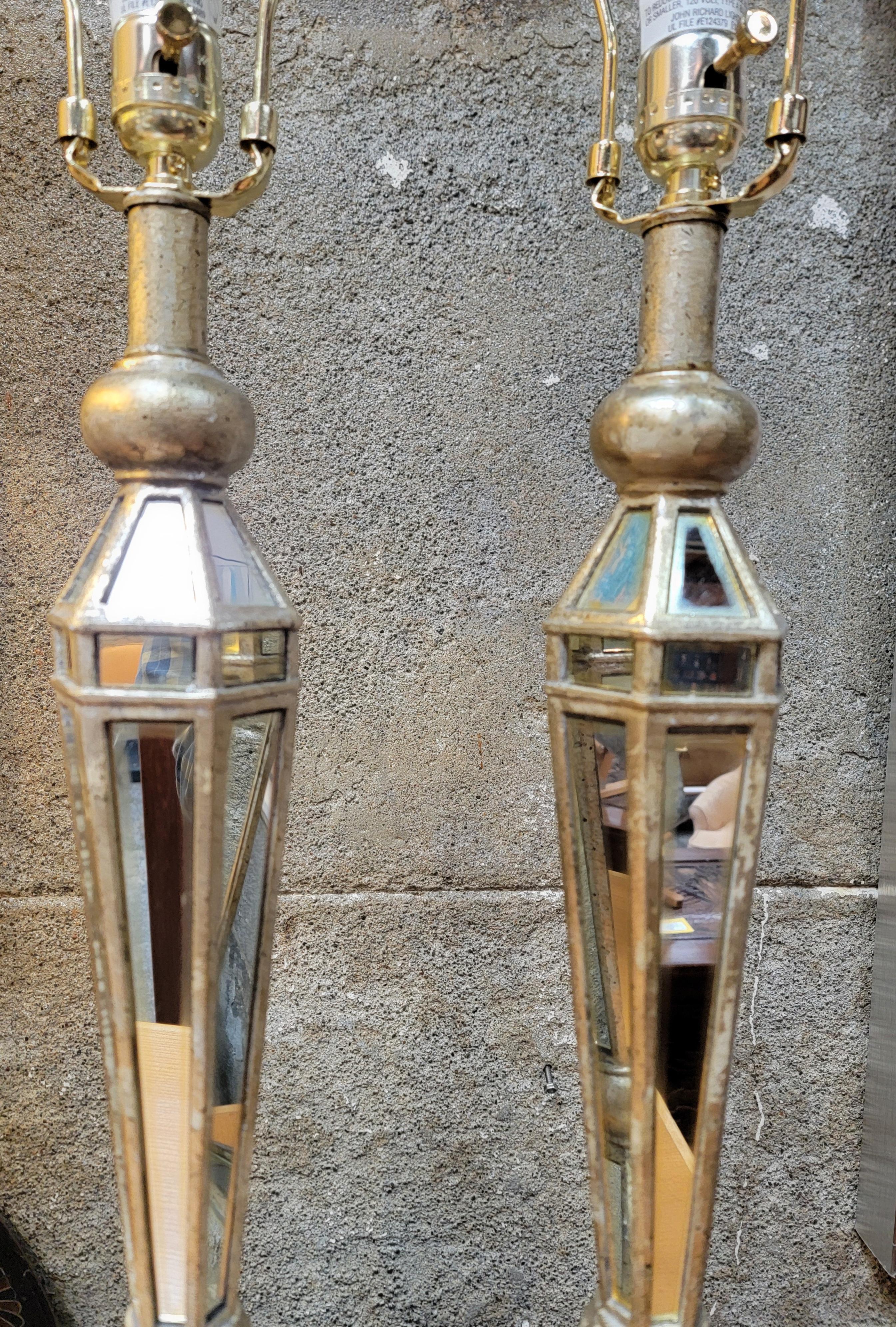 A pair of mirrored table lamps by John-Richard lighting. Retaining paper label and original finials. Excellent original condition. Shades not included. Measure 30.25 inches to top of finial. 