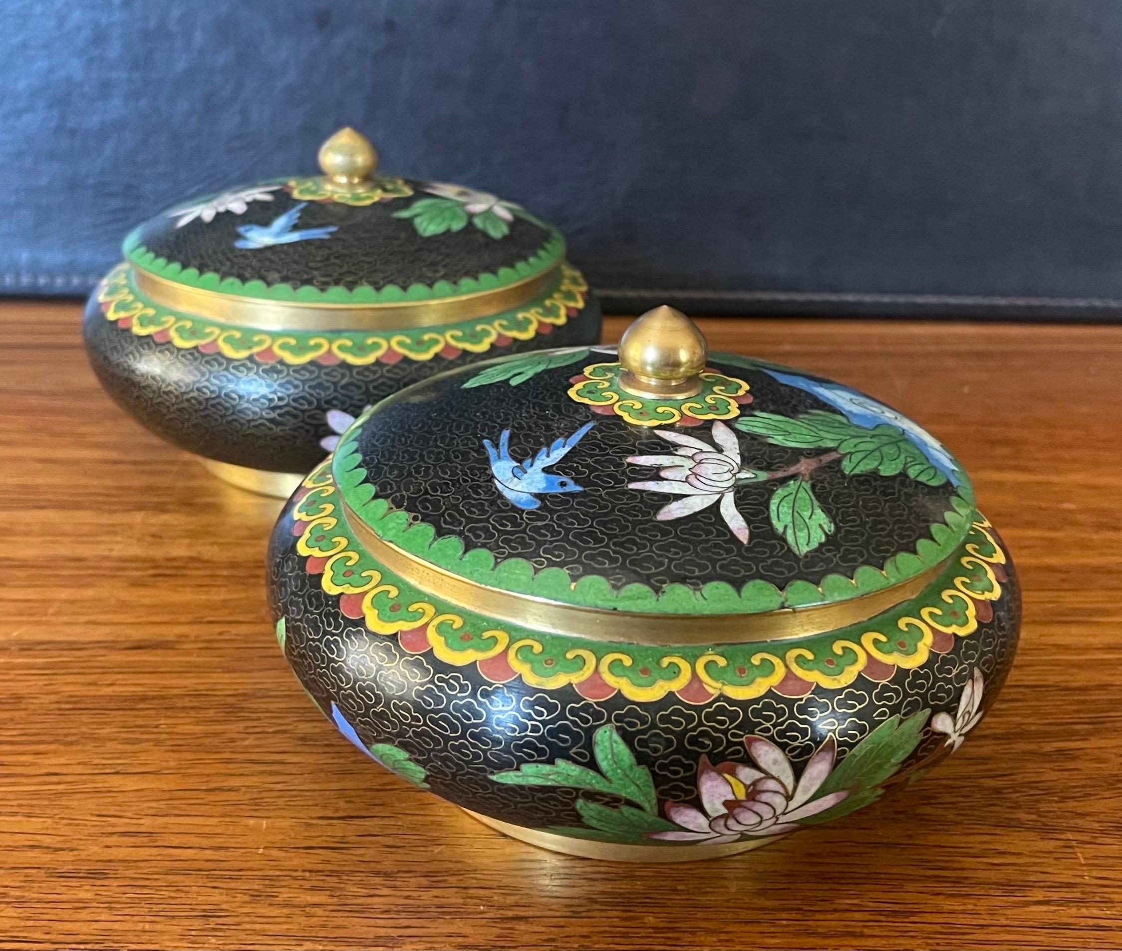 A nice mirrored pair of Chinese cloisonne lidded bowls with floral motif, circa 1950s. The bowls are in very good condition with no dings or dents and measure 6.5