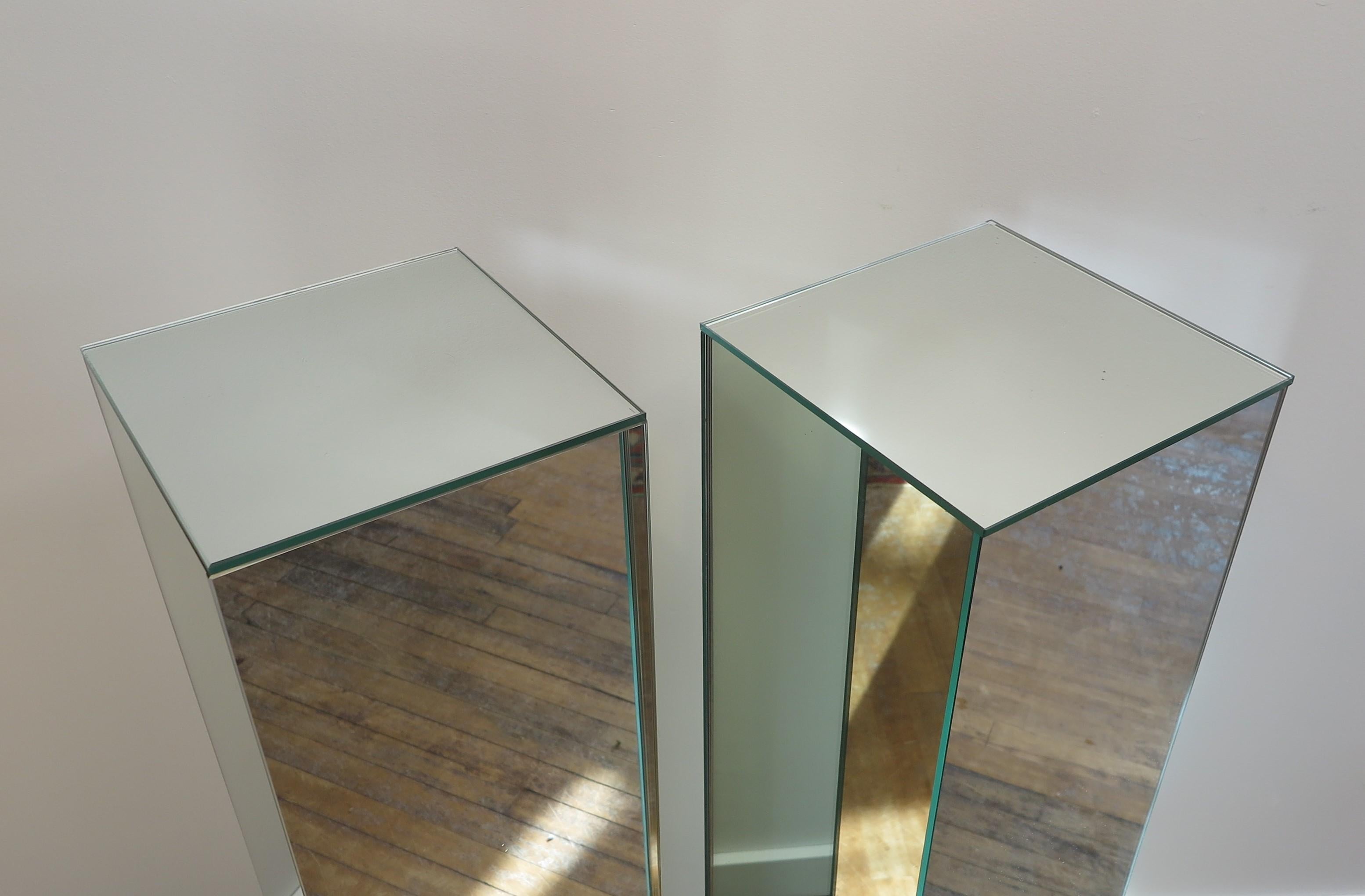 A pair of Mirrored Pedestal Stands. Mirrored on all four sides in very good condition. Made in 1976 for a art collector who displayed different glass and pottery art. These are a very good solid pair in very good condition, no chips.