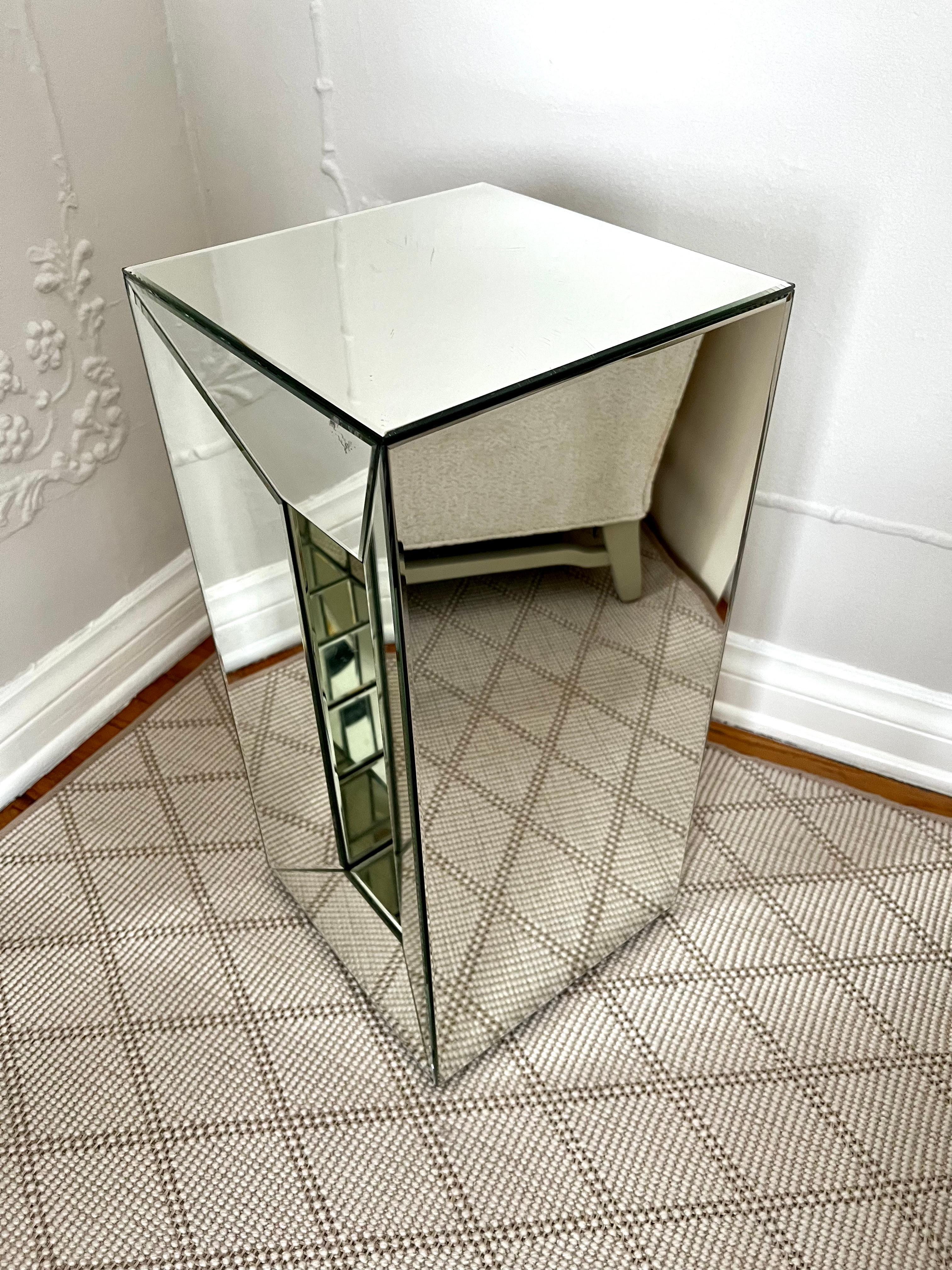 A simple mirror pedestal with a mirror cut-out that is asymmetrical to the piece. A compliment to many interiors and easily used for everything from art to plants and can be a side table or martini table - chic and simple