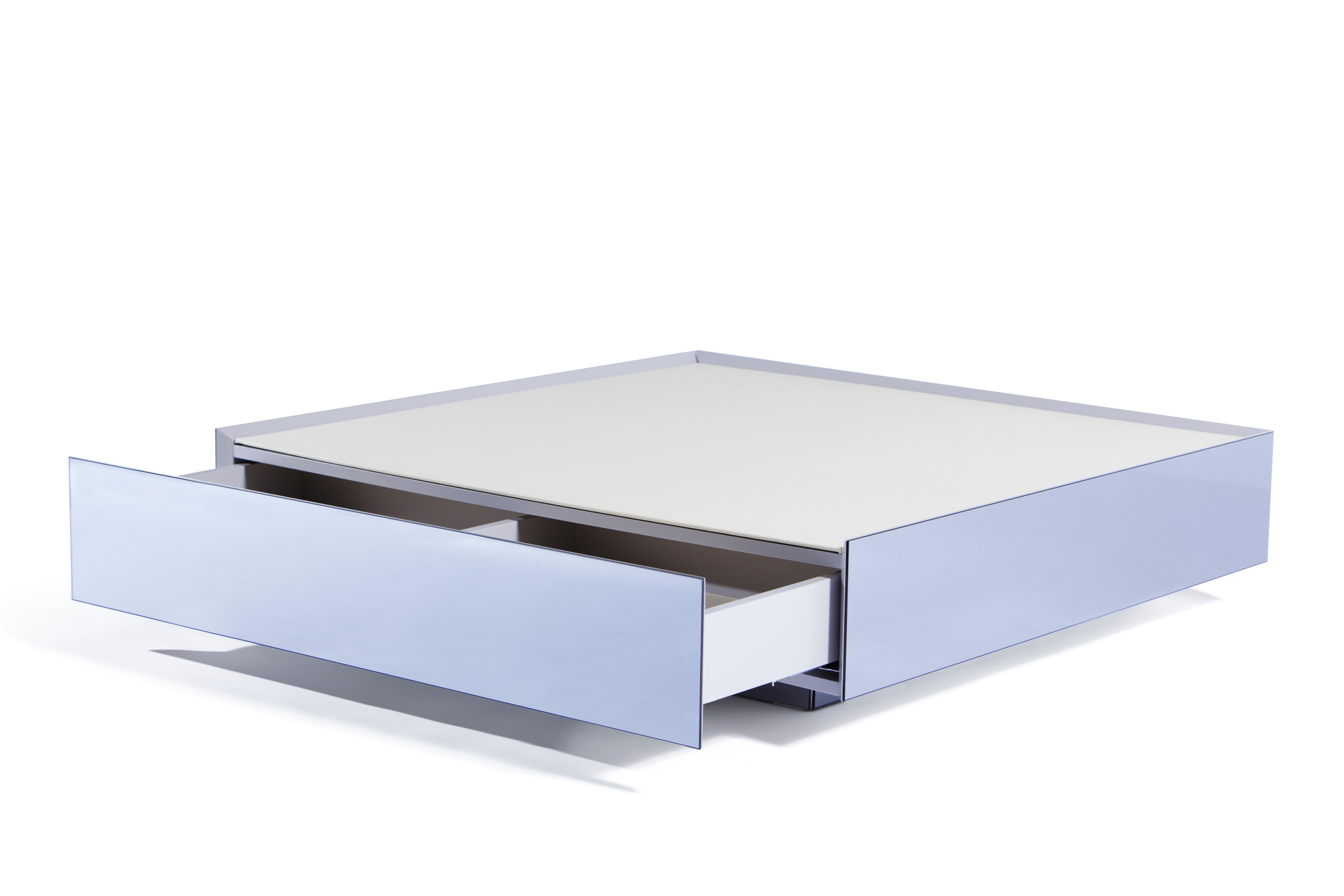 Inspired by a royal chest this clean and representative coffee table bears a secret. A hidden drawer adds to its simplistic yet elegant design a functional component. To personalize it to taste and functionality, the finishes of sides and top can be