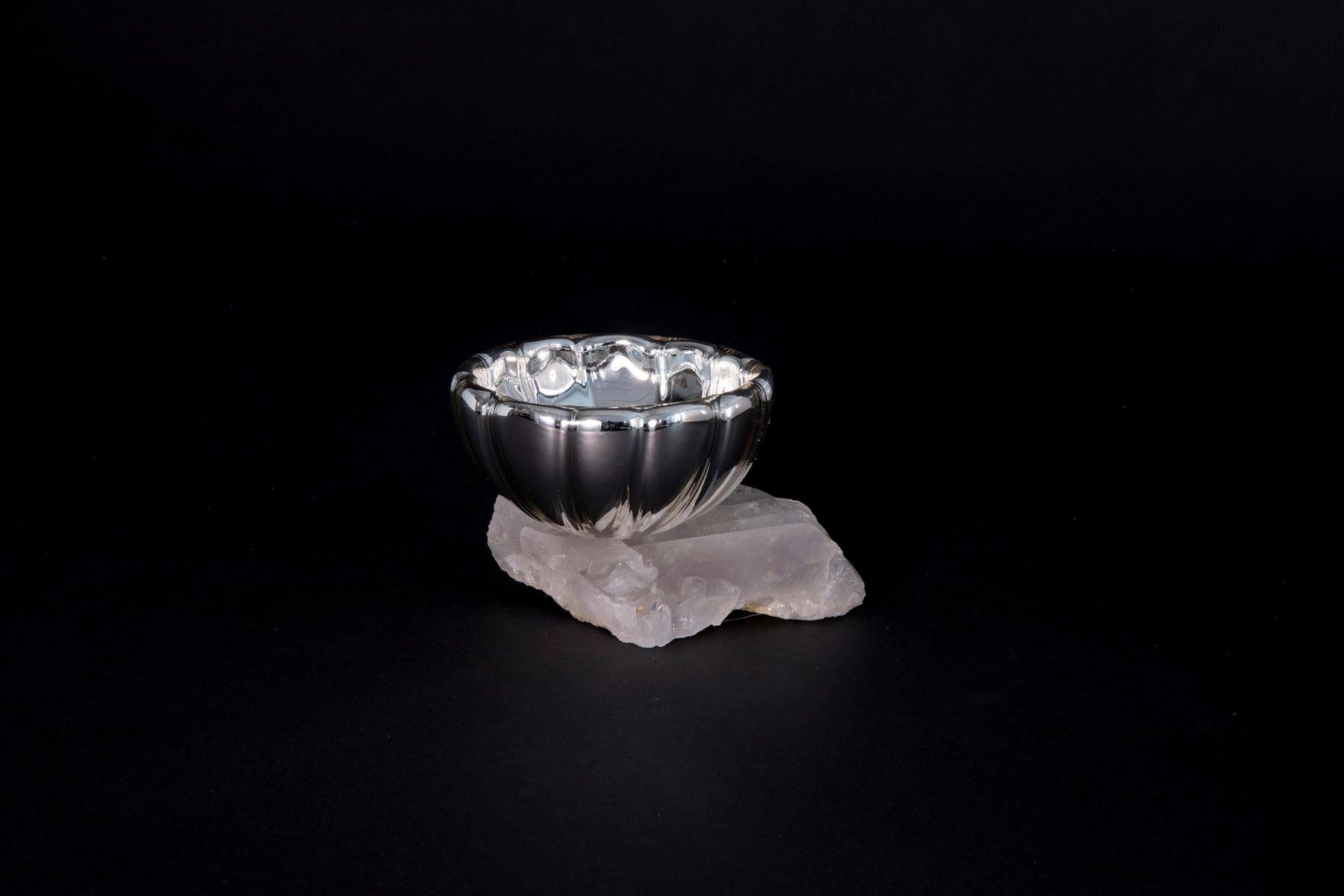 This flawless glass bowl is chemically bound to some of earth's most beautiful treasures. The textural contrast between these two bodies is what makes the piece so striking. When something is placed in the bowl the reflective quality of the interior