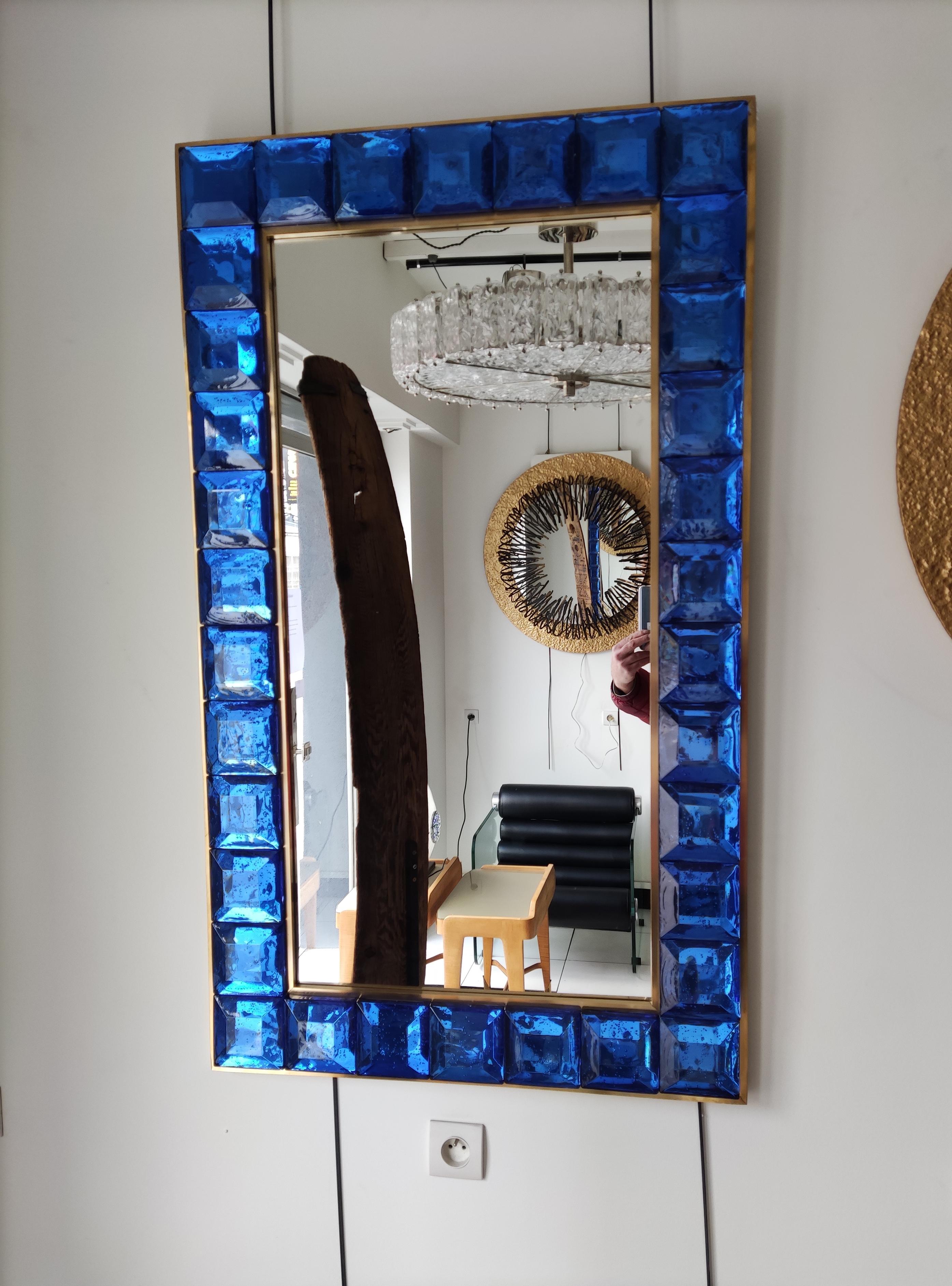 Mirror made of 34 truncated pyramids (blue Murano glass) in a brass frame
(on wood panel)
Measures: 123 cm x 73 cm
Height or width position.