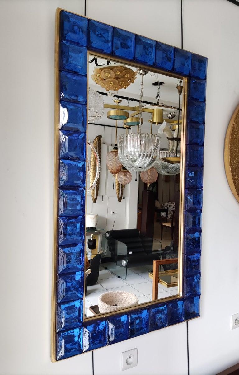 Specchio composto da 34 piramidi tronche (vetro di Murano blu) in una cornice di ottone
(su pannello di legno)
Misure: 123 cm x 73 cm
Posizione in altezza o in larghezza.