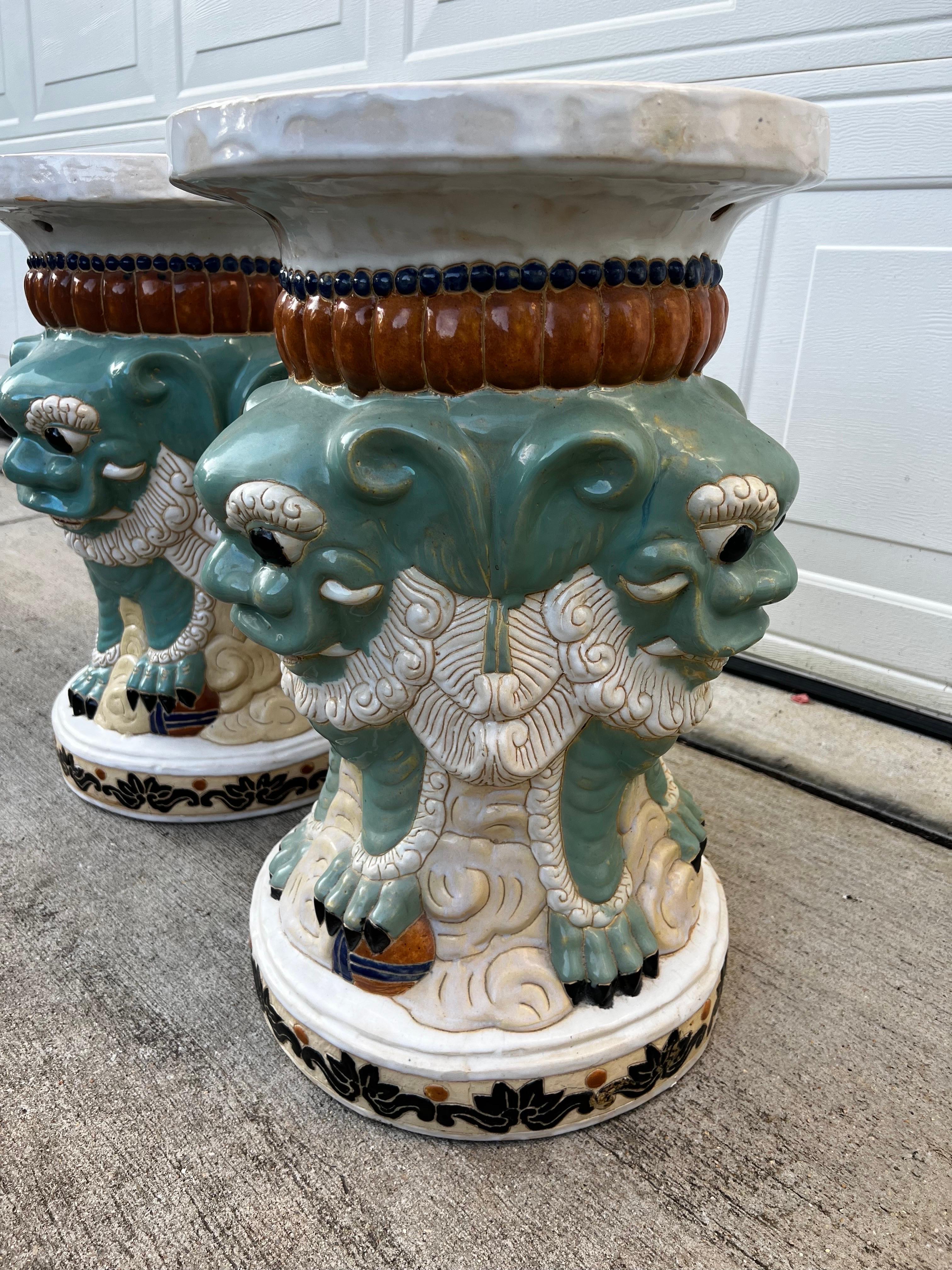 Stunning rare pair of a 3 face foo  dog garden stools, beautiful details and gorgeous colors. Teal, black, burgundy and white. This pair could be use indoor or outdoor 
Very unique way to add an Asian decor item to your home 
Please visit my store