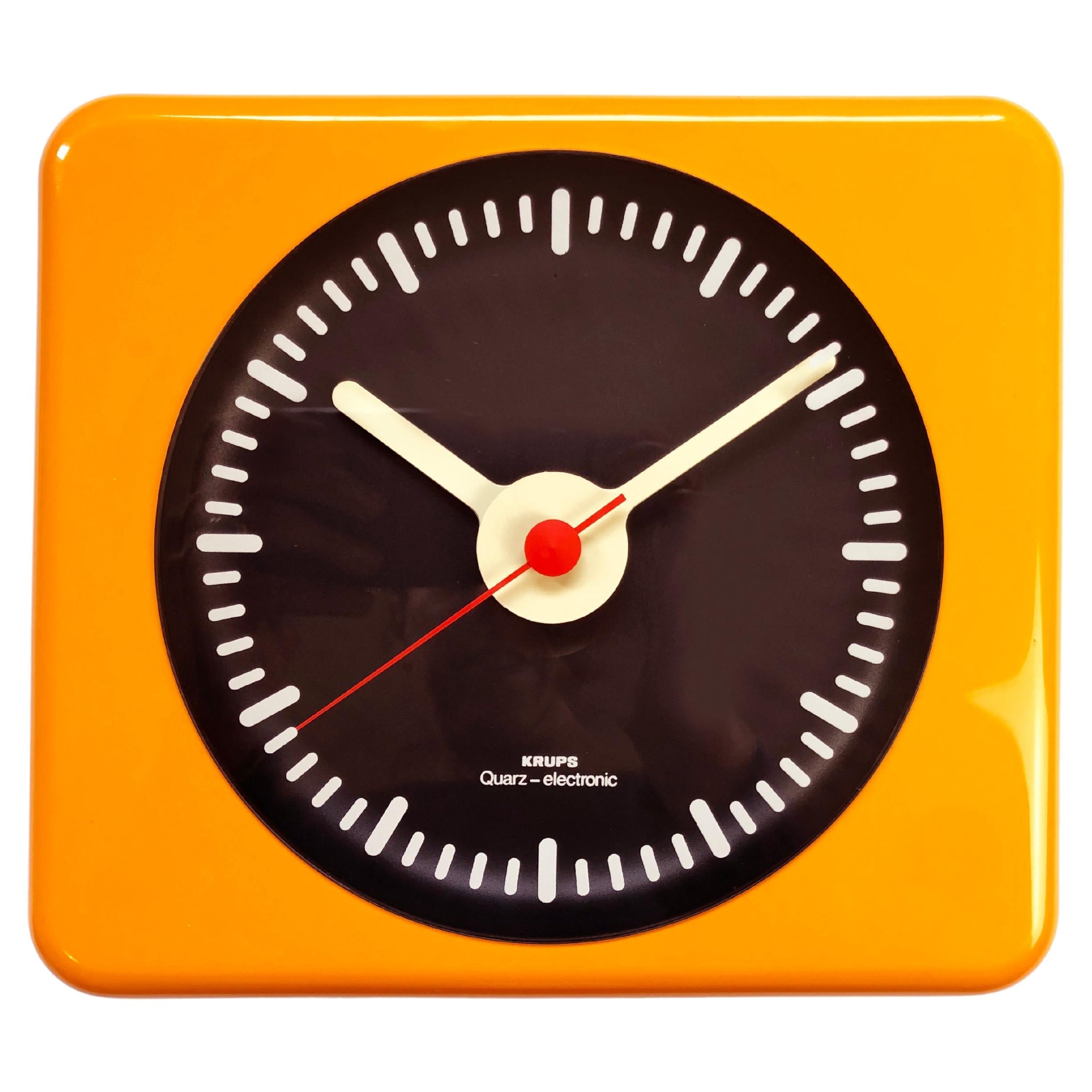 Absolutely fantastic colours & design by the star of German mid- and late century design, KRUPS.
Made in the late 60s, early 70s.
Here a juicy orange wall clock, with black dial, white 'numbers' & pointers, shaped round!
Beautiful also the fiery