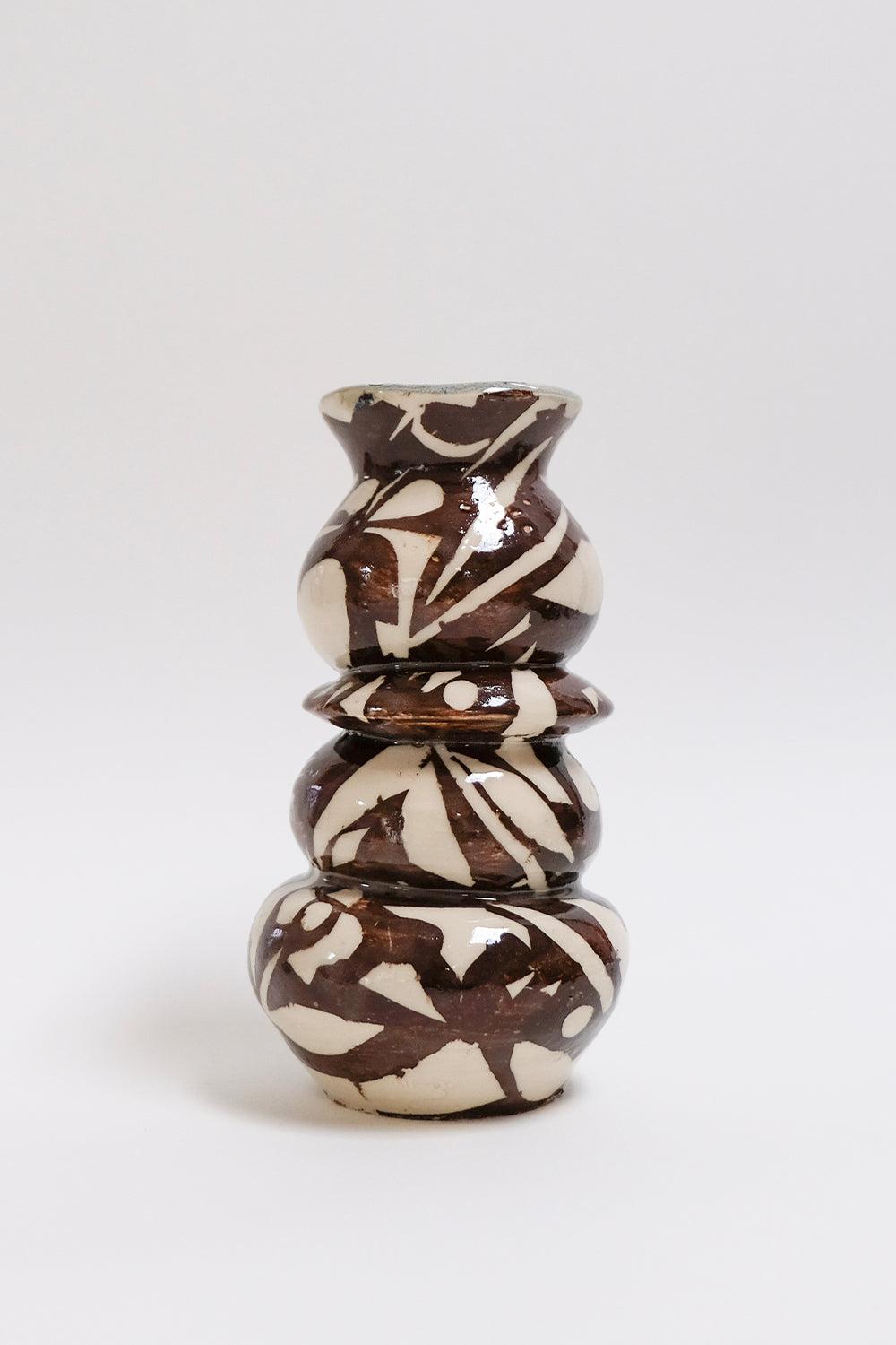 This contemporary brown and white ceramic vase features a surface pattern that combines botanical and geometric shapes and is an original artwork by Canadian artist Misbah Ahmed. This piece from her collection of Mur vessels explores organic
