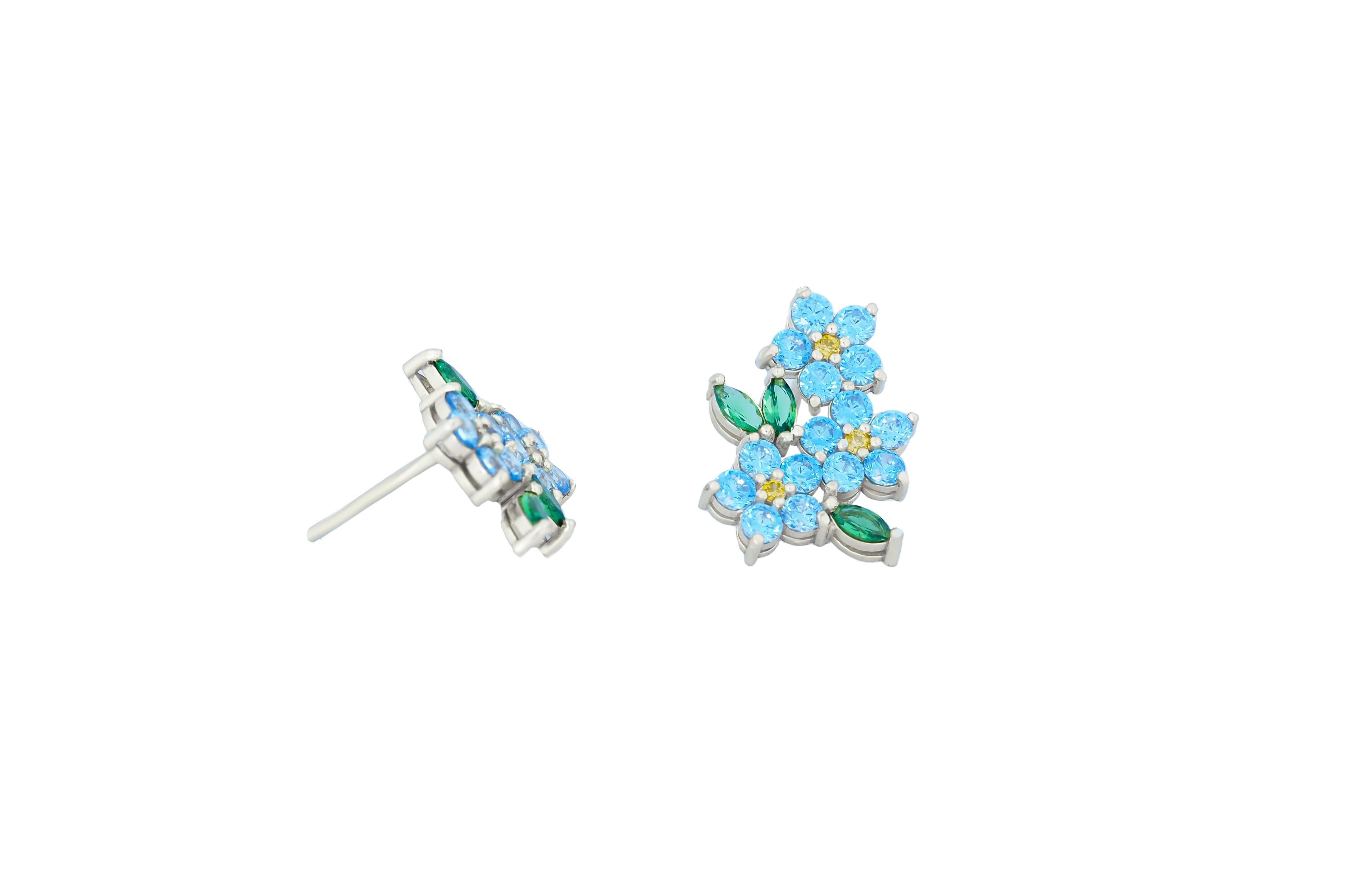 Ungleiche Blumenohrringe mit farbigen Edelsteinen in 14k Gold.
Vergissmeinnicht Blume 14k Gold Ohrringe Ohrstecker. Kornblumen-Ohrringe Ohrstecker. Blaue Topase und gelbe Saphire als Ohrstecker. 

Gewicht: 2,2 g.
Metall: 14k Massivgold
Die Ohrringe