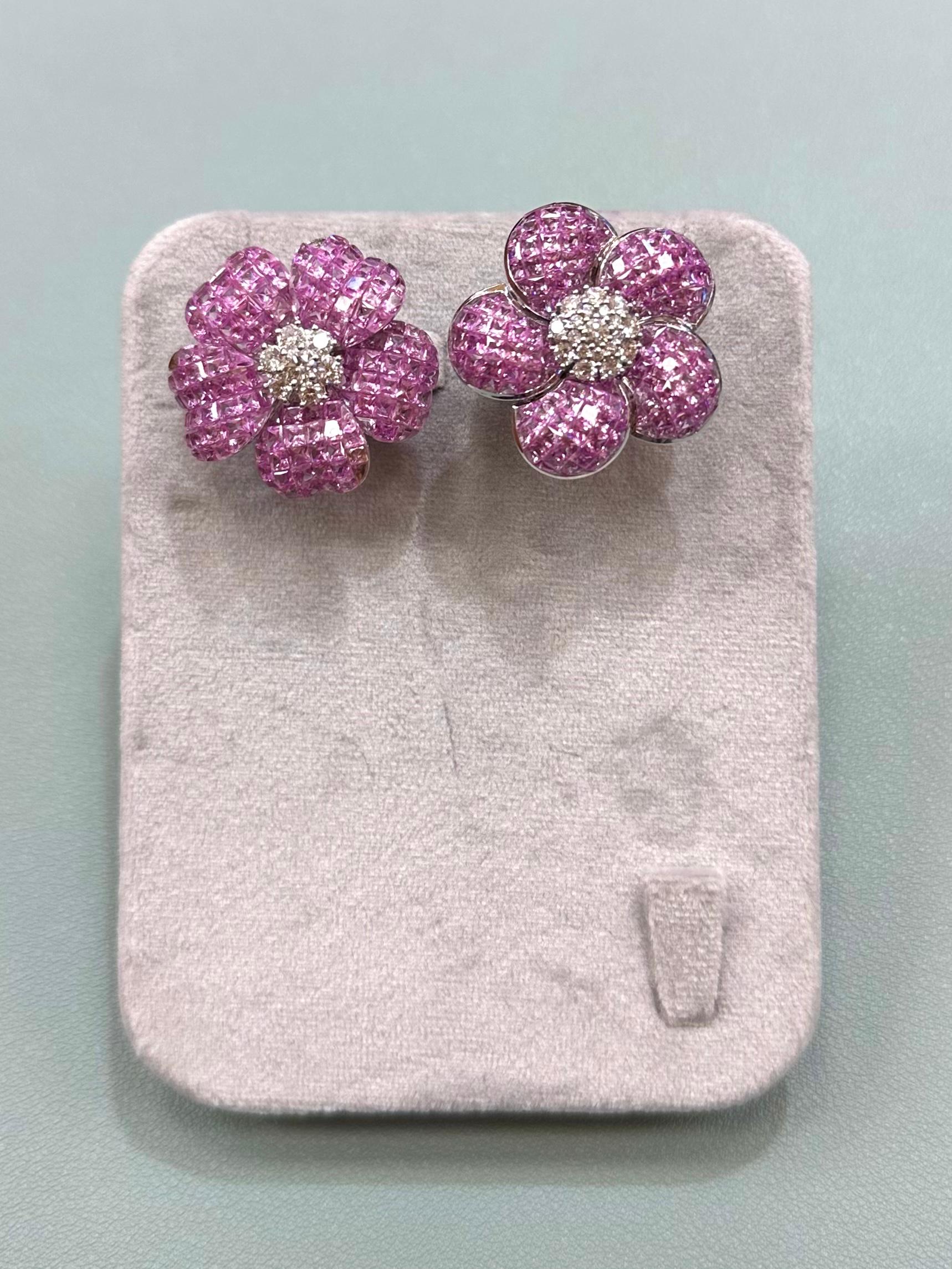 Ungleiche, unsichtbar gefasste Blumenohrringe aus rosa Saphiren und Diamanten in 18 Karat Weißgold mit über 1,10 ct Diamanten und 8,75 ct rosa Saphiren. 

Insgesamt 30,88 Gramm für beide Ohrringe.