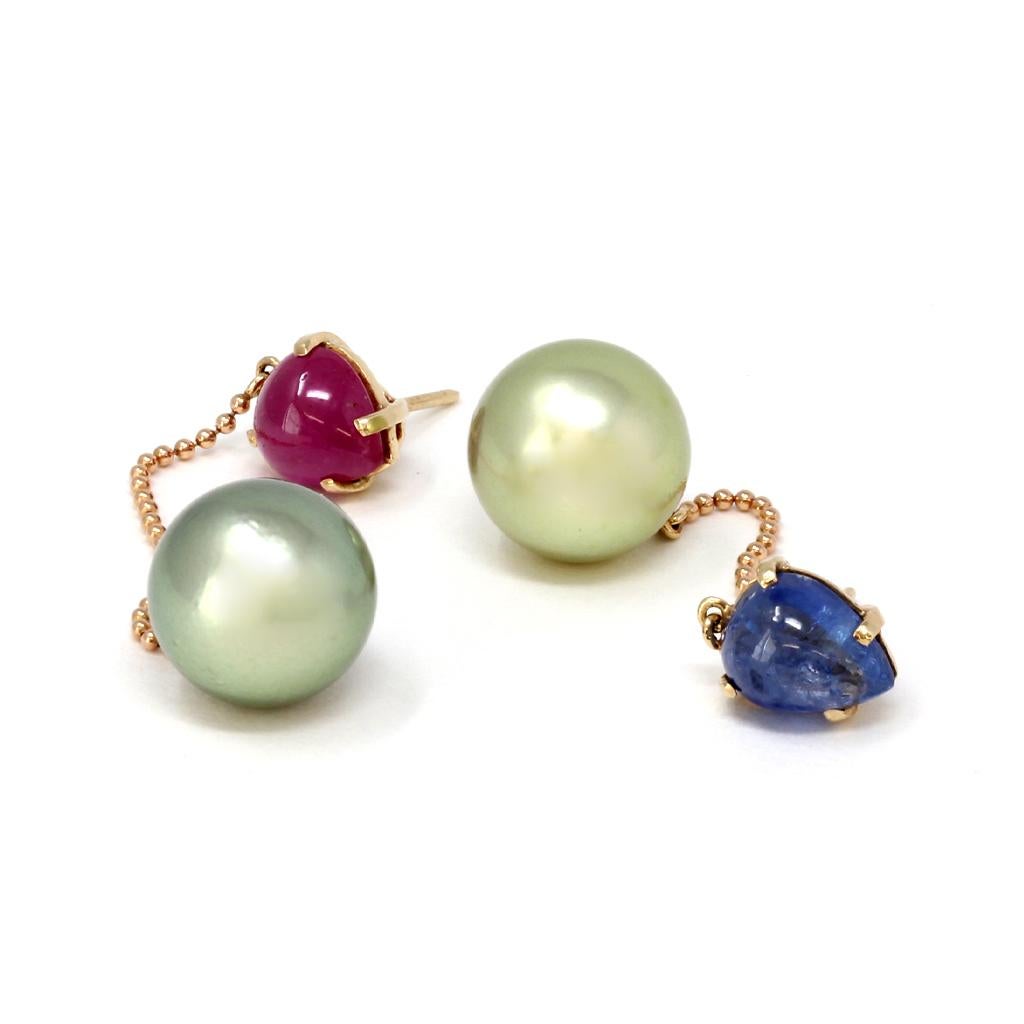 A pair of mismatched cabochon pear shape ruby and blue sapphire dangling earrings with pistachio round Tahitian pearls. This fun dangling earrings features a cabochon ruby stud on one earring and a blue sapphire cabochon on the other with dangling