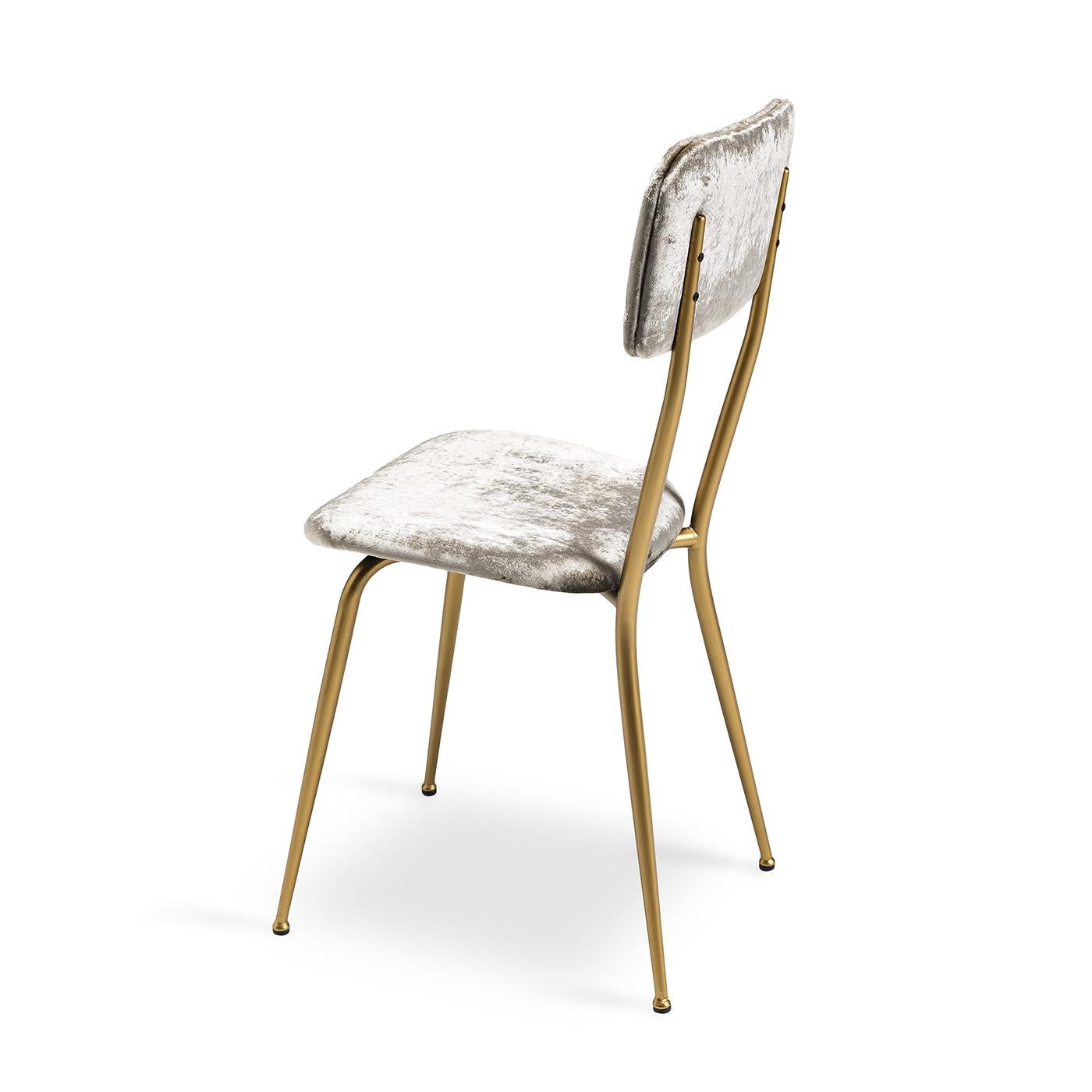 This little vintage dining chair has a sleek look with its metal frame finished in a matte brushed brass finish. The seat and back, which are comfortable and structured thanks to polyurethane and curved wood inside, are upholstered in a