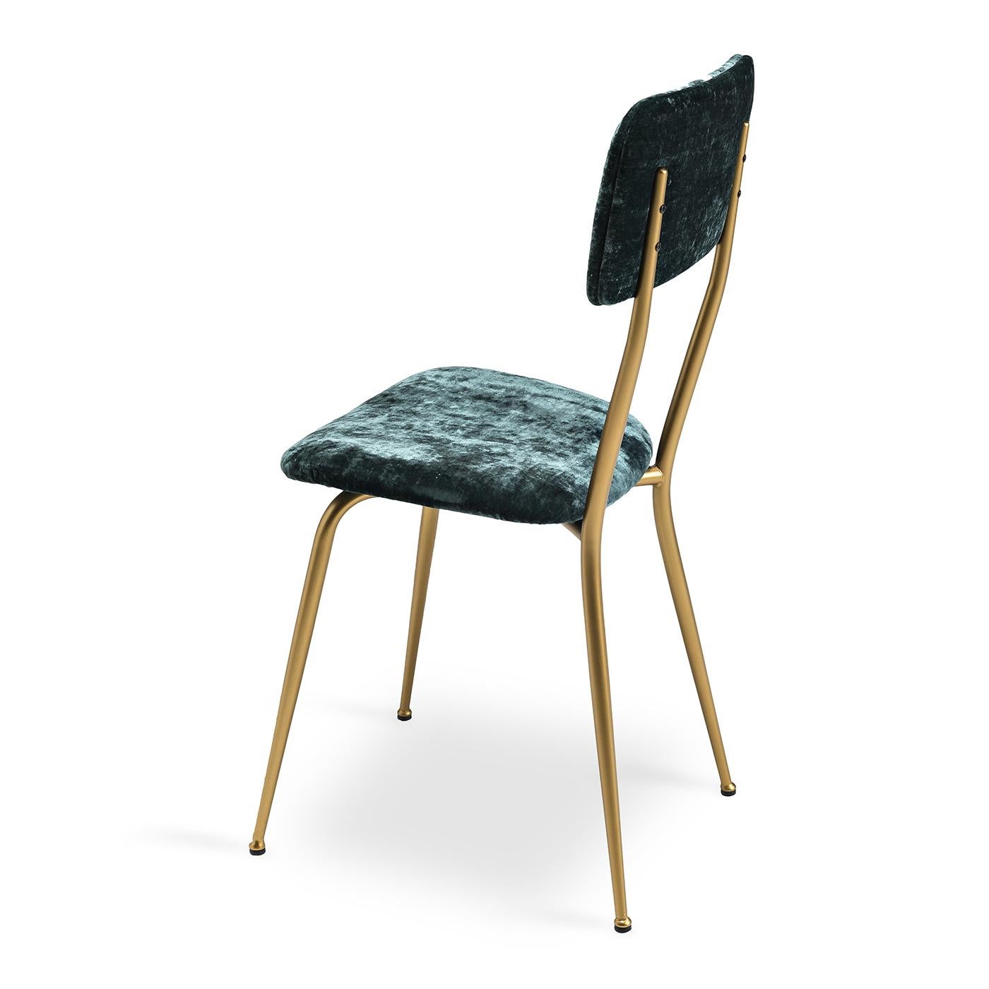 Der Stuhl Miss Ava 13 zeichnet sich durch ein schlankes Metallgestell mit gebürstetem Messing aus. Der luxuriöse ozeanblaue Samtstoff, mit dem Rückenlehne und Sitzfläche des Sessels bezogen sind, ergänzt die Metalltöne mühelos: eine harmonische