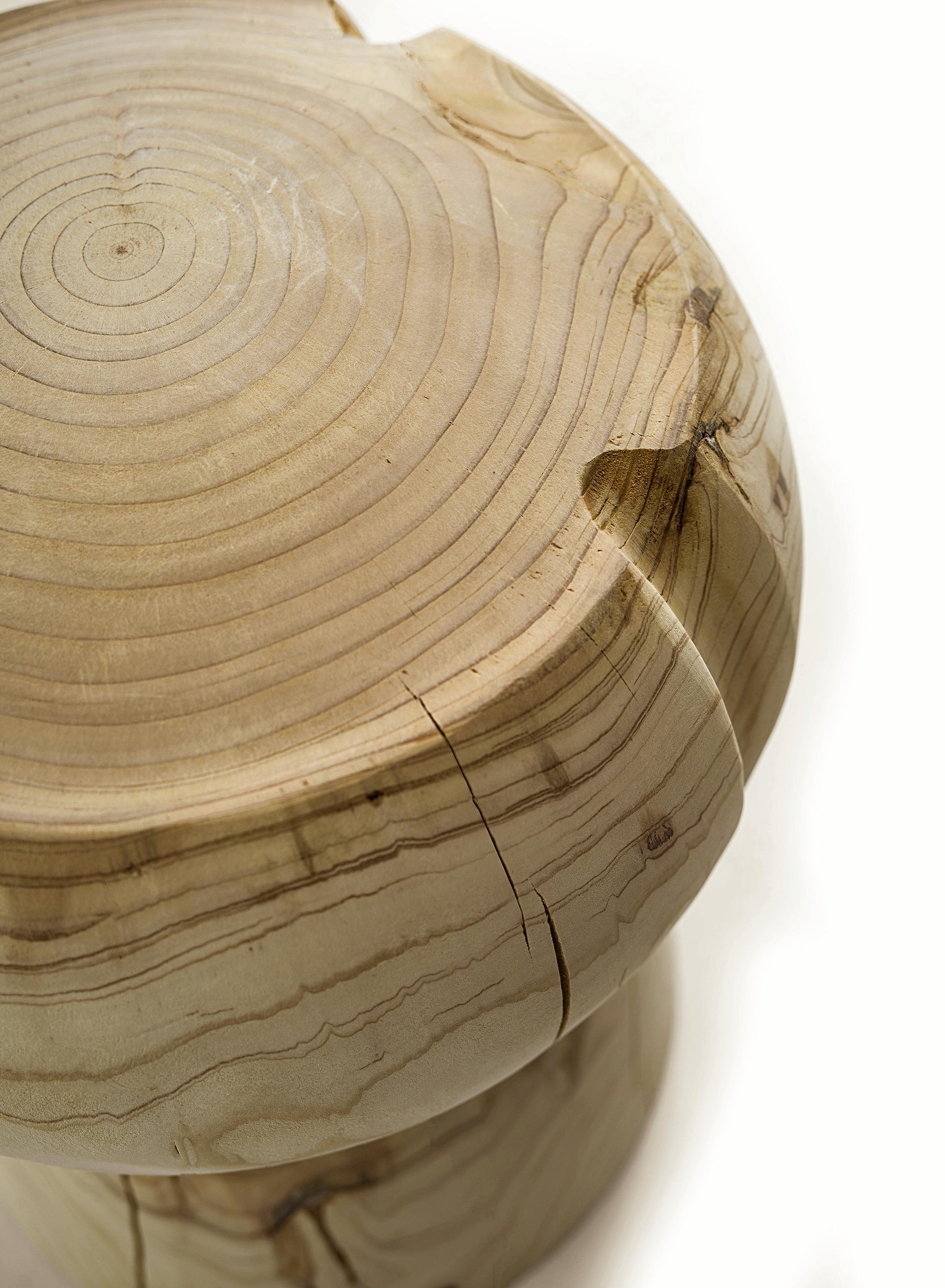 Stool made from a single block of scented cedar that is a representation of a large cork used in champagne bottles.