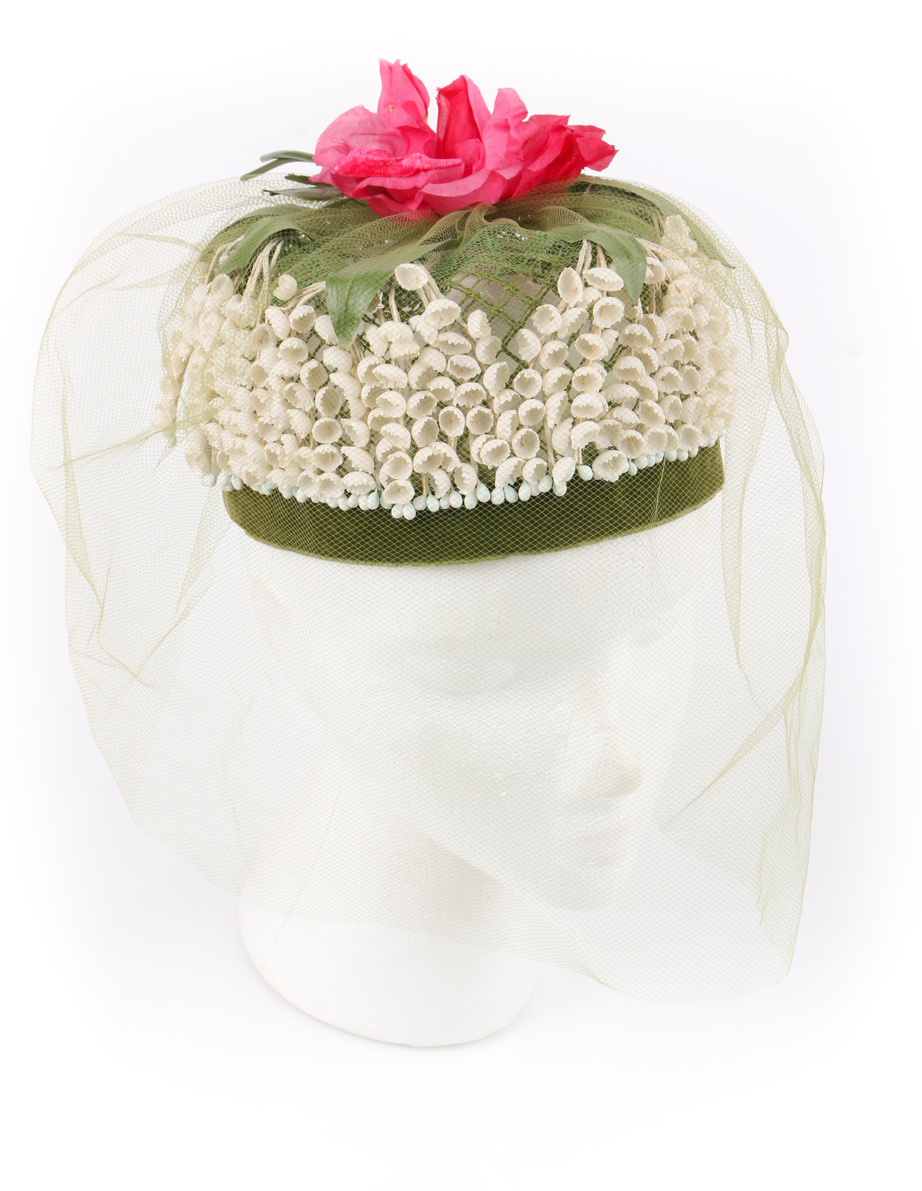 DESCRIPTION: MISS FEIGE c.1960's Lily of the Valley Veiled Floral Garden Party Pillbox Hat
 
Circa: c.1960’s
Label(s): Styled by Miss Feige; Union Label
Designer: 
Style: Pillbox
Color(s): Shades of gree, off white, and pink
Lined: No 
Marked Fabric