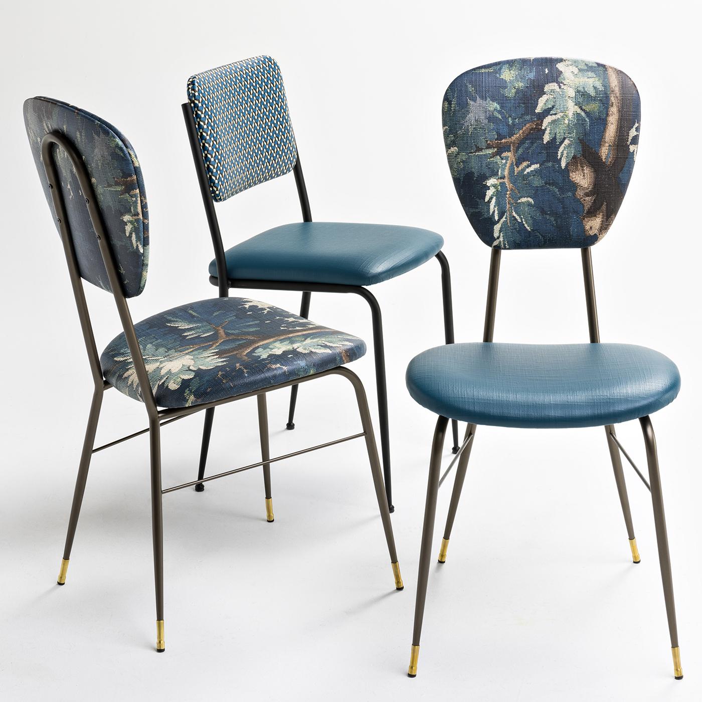 A beautiful chair for around a dining table, perhaps with a bit of a vintage feel. The metal frame and legs have a brushed bronze finish, while decorative brass chair guides adorn the legs. The seat is upholstered in an ocean-blue colored, fireproof