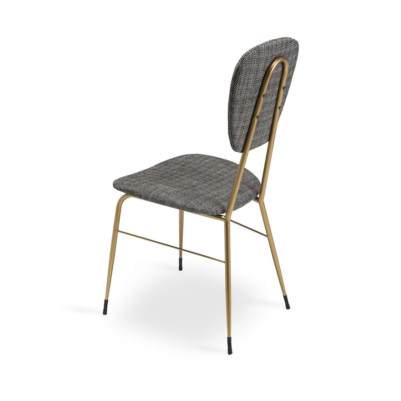 Give your dining table space a bit of a vintage feel with this cute little dining chair. The simple metal frame and legs are finished in a matte brass finish, with decorative black metal chair guides at the bottoms of the legs. The back and seat,