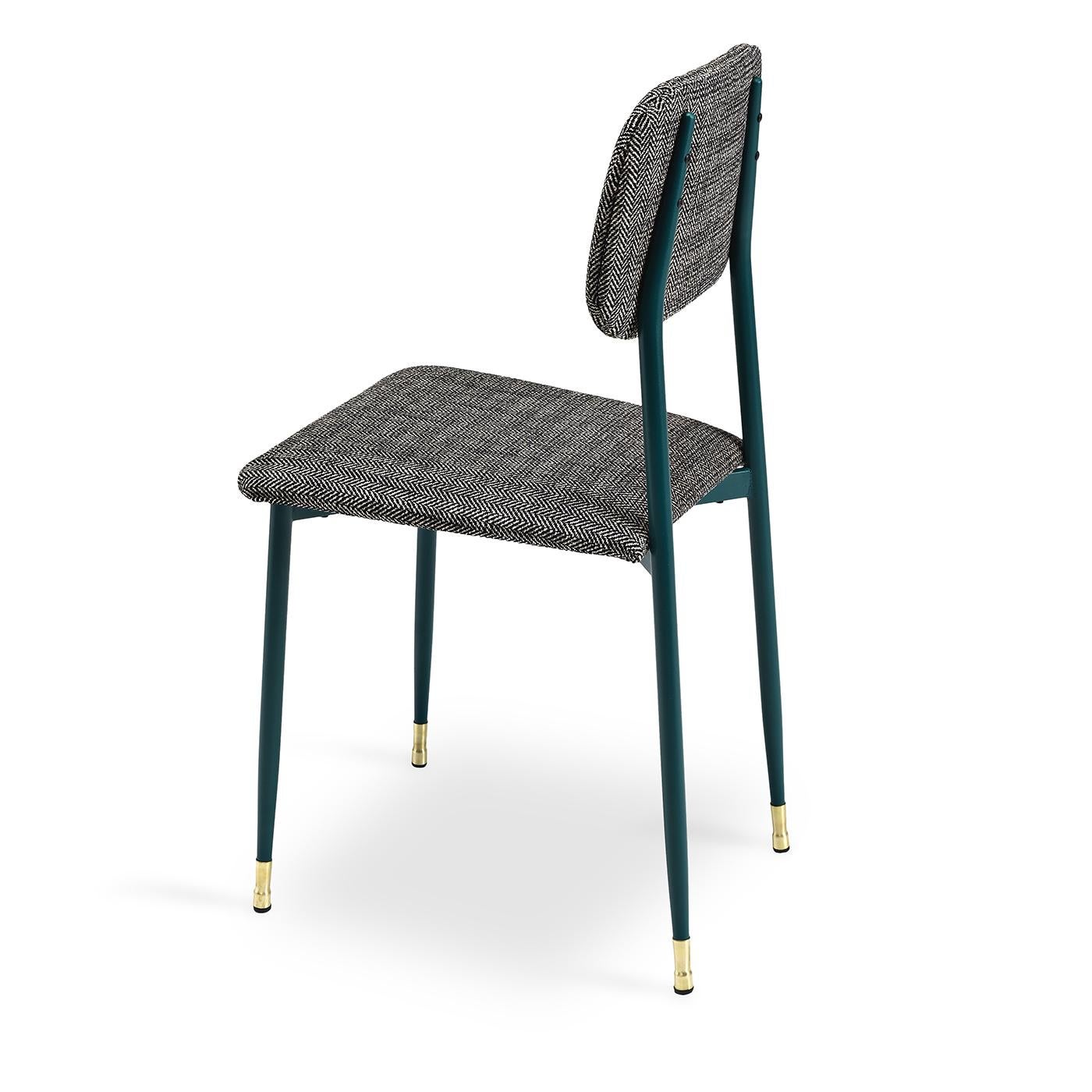 Sit around the table on this cute little dining chair with a vintage spark. The chair’s simple metal frame and legs are finished in a dark green and decorative brass chair guides complete the bottoms of the legs. The comfortable back and seat are