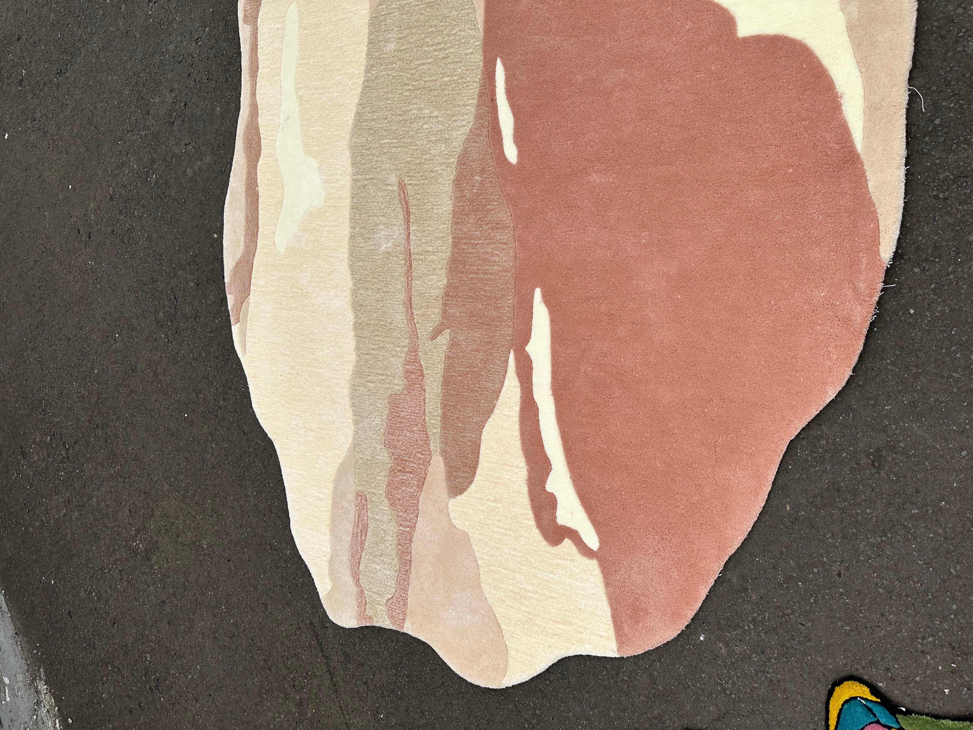 La forme Dune de Silhouette explore la beauté d'un design non structuré à travers une silhouette organique et libre inspirée par les lentes transformations de la nature. Ce tapis sculptural mélange les tons doux du désert - argile, blush, grès et