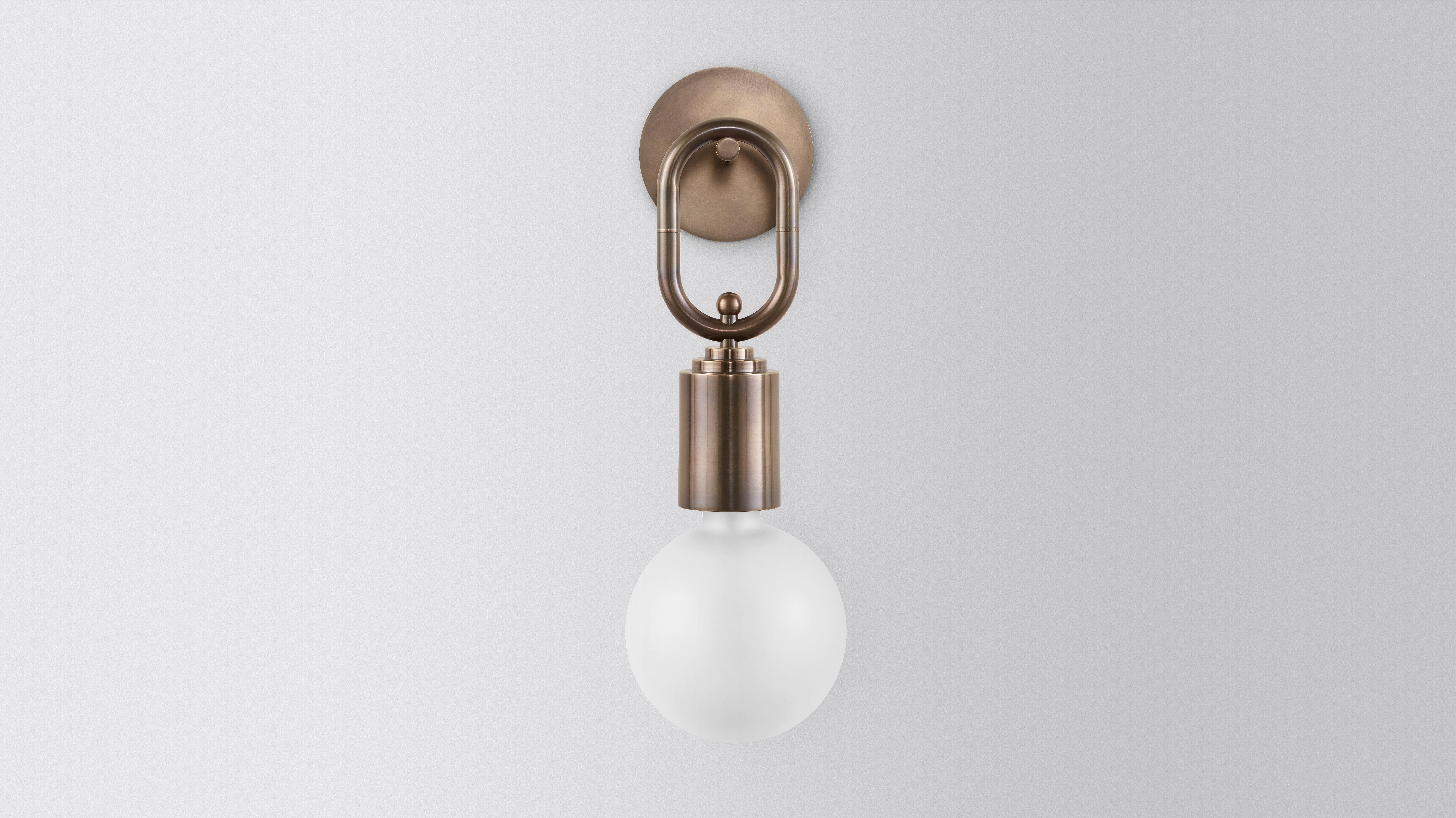 Missing link wall sconce by Volker Haug
Dimensions: Diameter 15 x H 34 cm 
Material: Brass. 
Finish: Polished, Aged, Brushed, Bronzed, Blackened, or Plated
Lamp: 240V G9 LED or 12V G4 LED
Glass Shell: ø 150 mm Opal or Frosted
Weight: Approx. 1