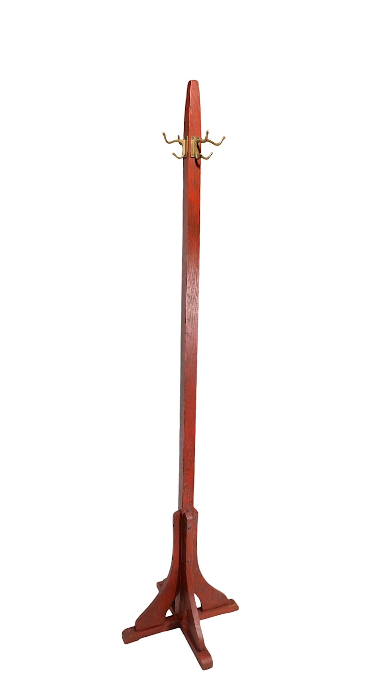 Arts and Crafts, Mission period coat tree, coat rack, constructed of solid oak, and cast brass. The freestanding stand features four brass arms each with two  hooks, one for coats, one for hats, scarves etc. This example is in very good, clean,