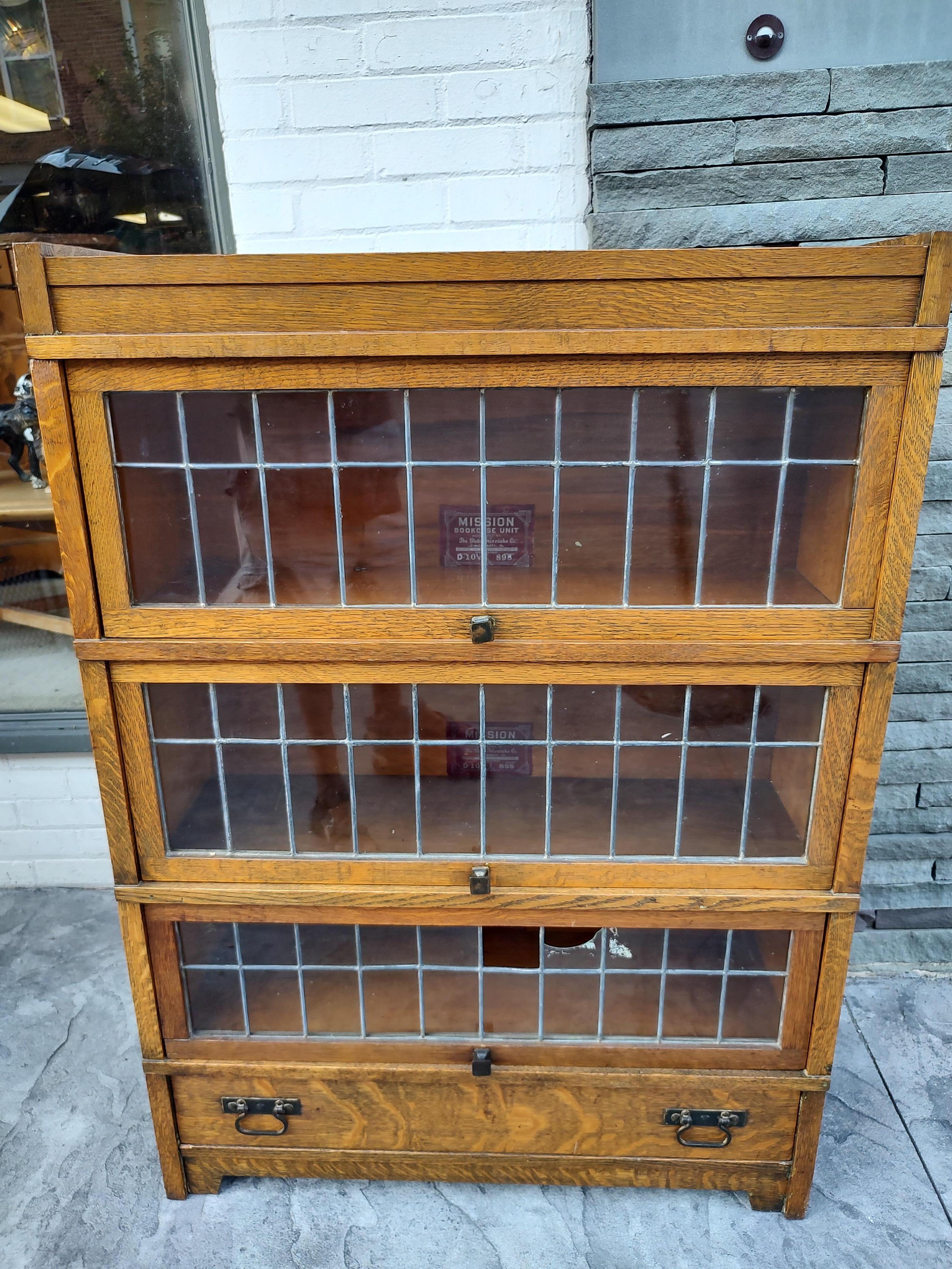 Fabulous arts & crafts mission bookcase with 5 sections, 3 leaded glass door compartments which have storage space. Sizes are, 32x 9.5x 10h, 32x 9.5 x 10.5h, 32 x 9.5 x 8.75h. Drawer at the base and top cap complete the set. Made from quarter sawn