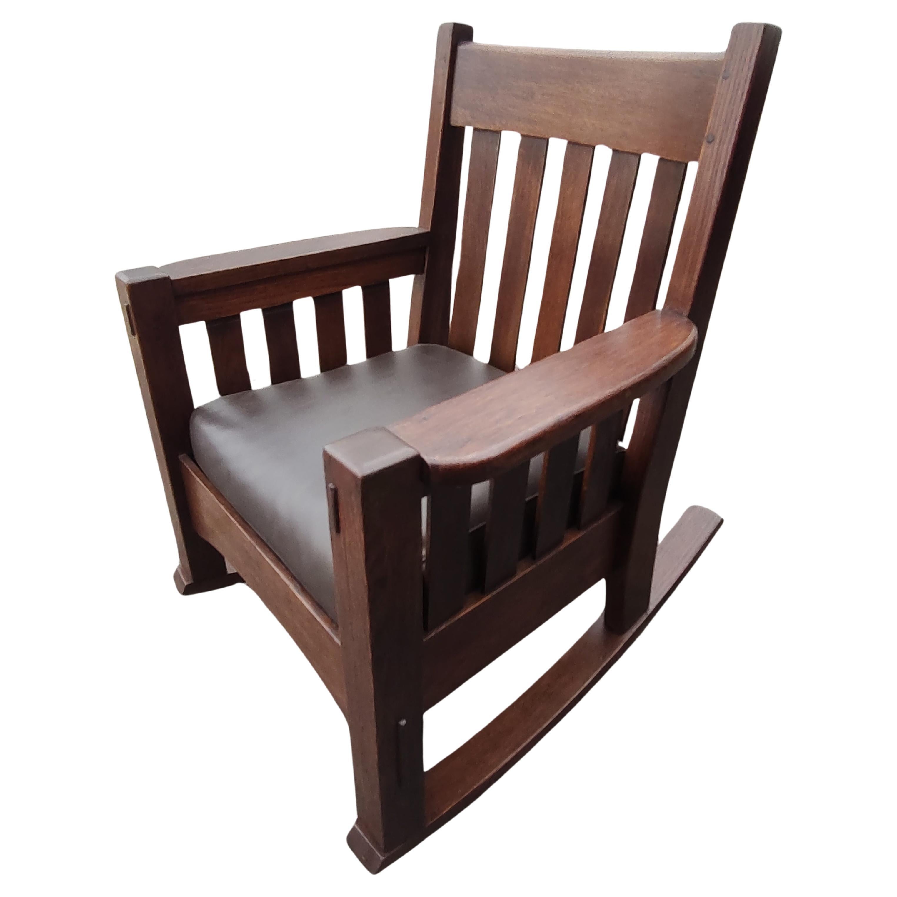 Fabulous large commanding arts & crafts rocker by The Harden co. Fantastic massive thick posts with wide and thick arms, slats underneath. Joints are mortise & tenon construction with wood pegs. Was recently refinished so it's ready for a new home.