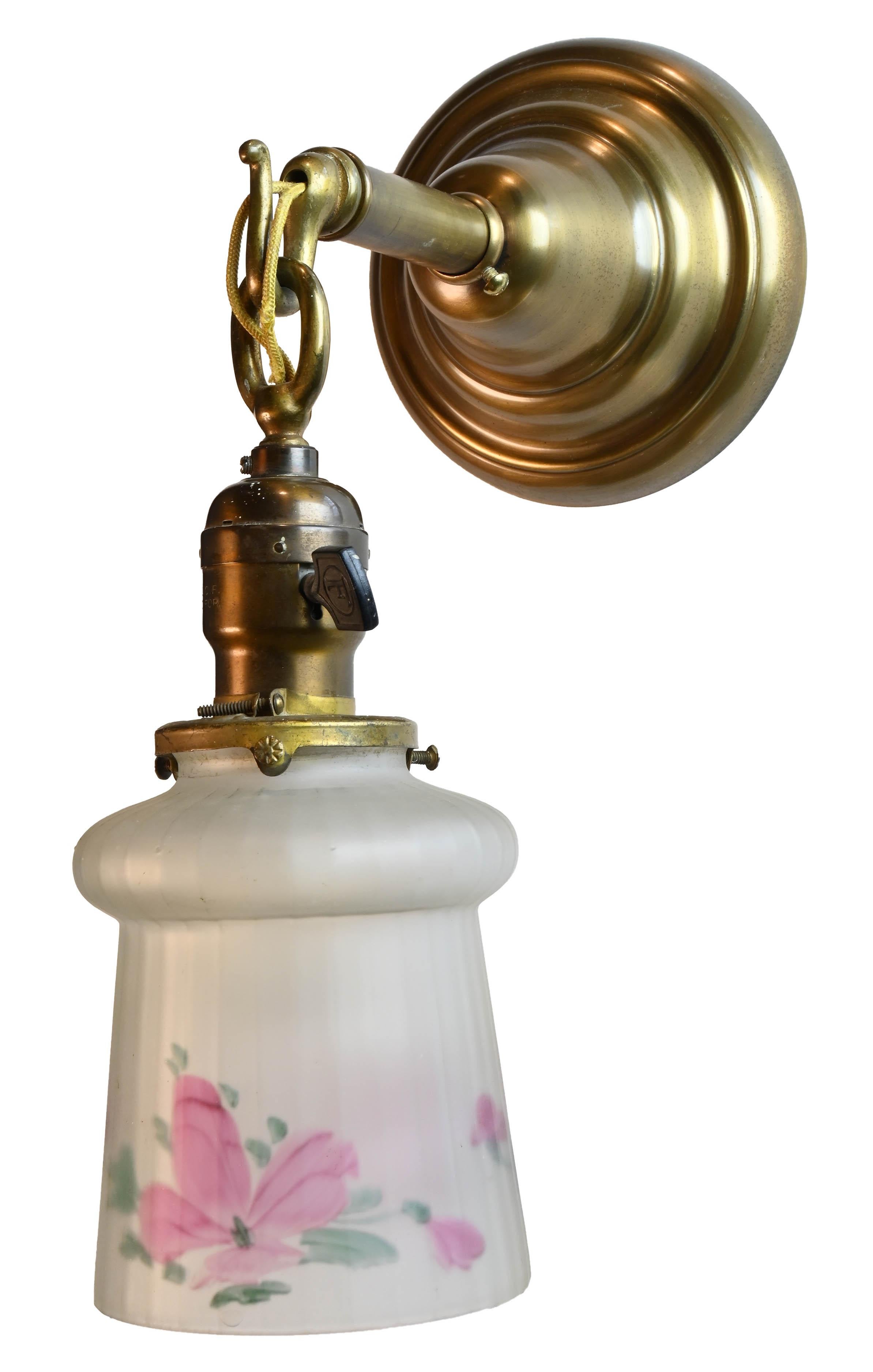 Beautiful rounded Mission sconces with hand painted pink floral glass shade.

Illumination: Single Edison socket 

Sconce dimensions: 5” wide x 12” tall with shade by 9” projection
Reverse hand painted shade dimensions: (5” tall by 4” wide,