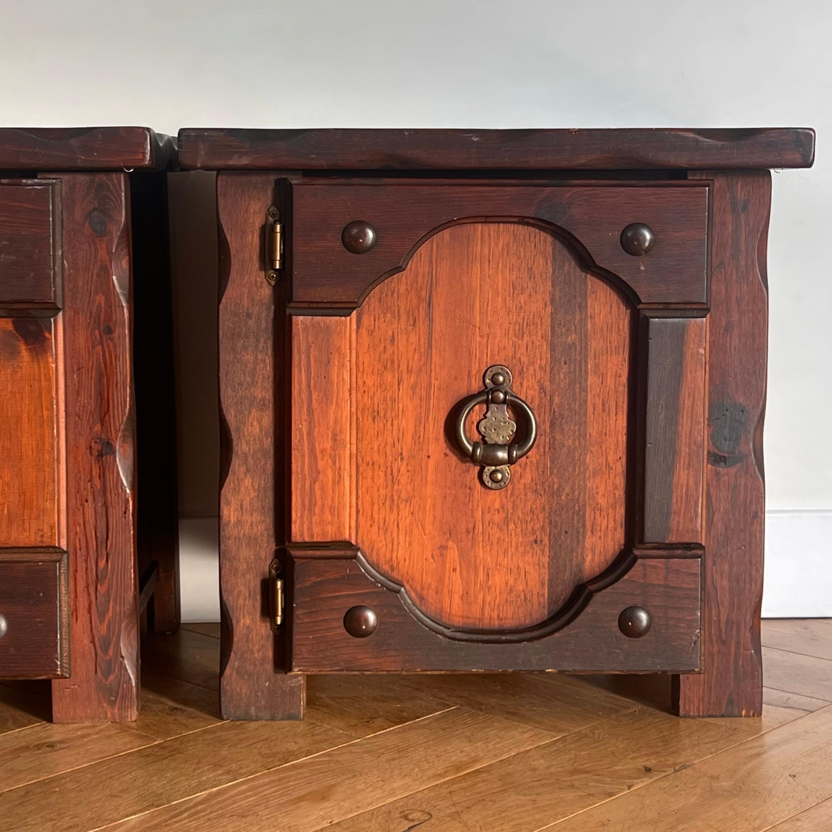 A pair of craftsman nightstands with mission and gothic sensibilities, circa early 1970s. Beautiful wood grain and iron accents and hardware. In great condition with only minor signs of age including some nicks to wood as shown in photos. Pick up in