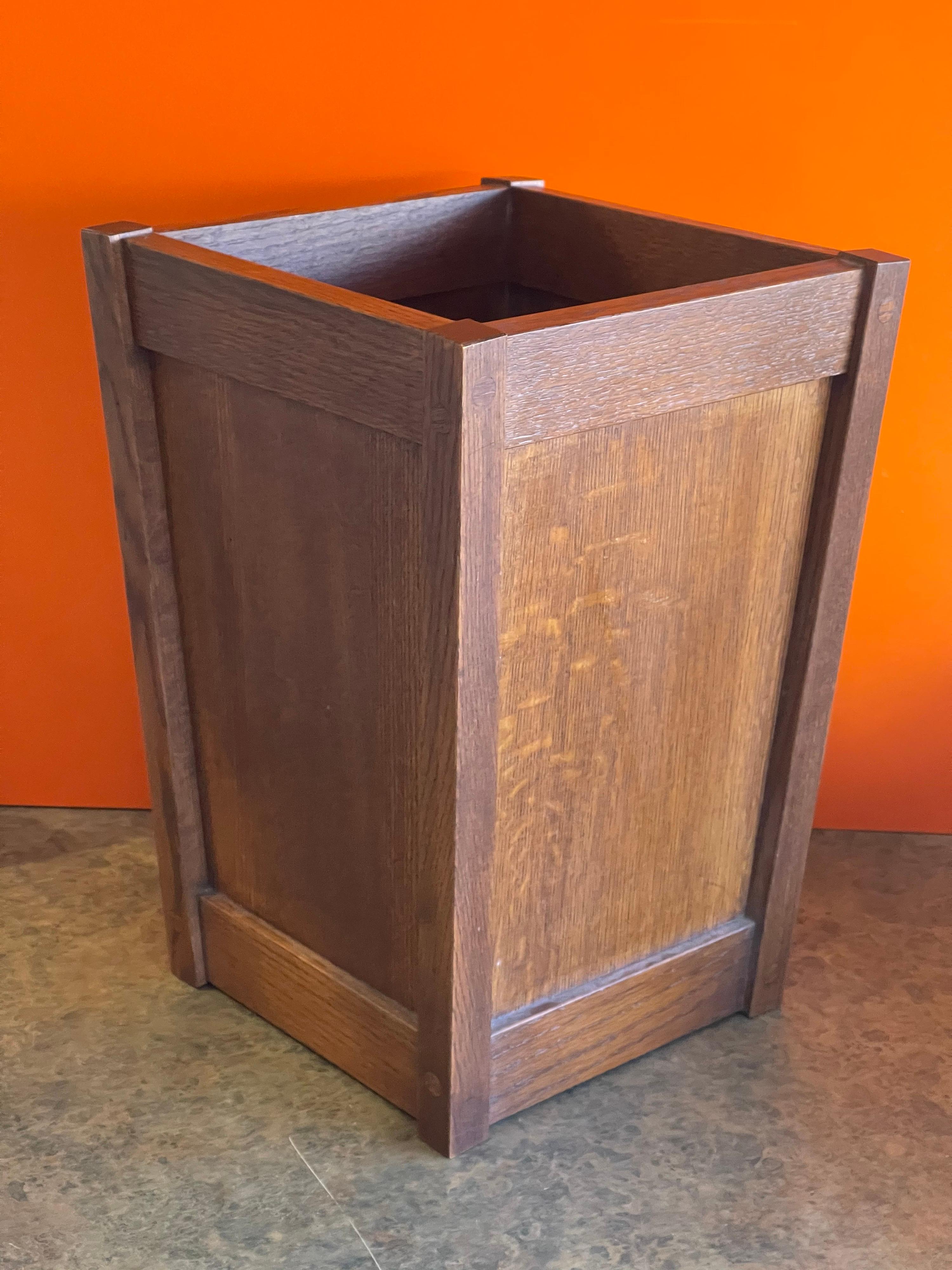 A very well constructed mission / craftsman style American quarter sawn oak waste basket, circa 1990s. The waste basket is in very good condition and measures 11