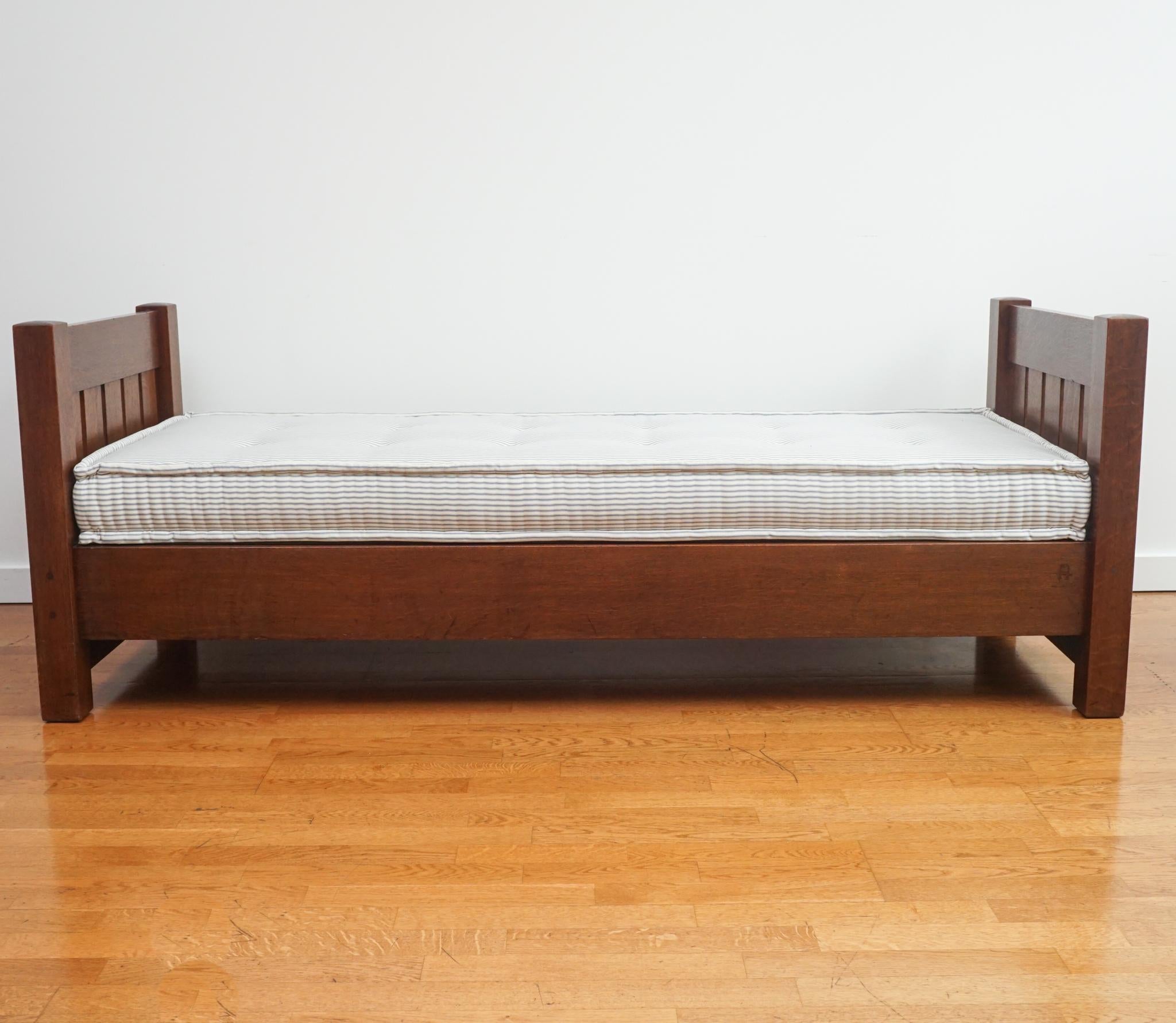 The Mission daybed, shown here, is a classic for all time. Made of solid oak, the finish has been gently restored, the support deck for the mattress replaced, and the button-tufted mattress custom made in ticking stripe with traditional French welt.