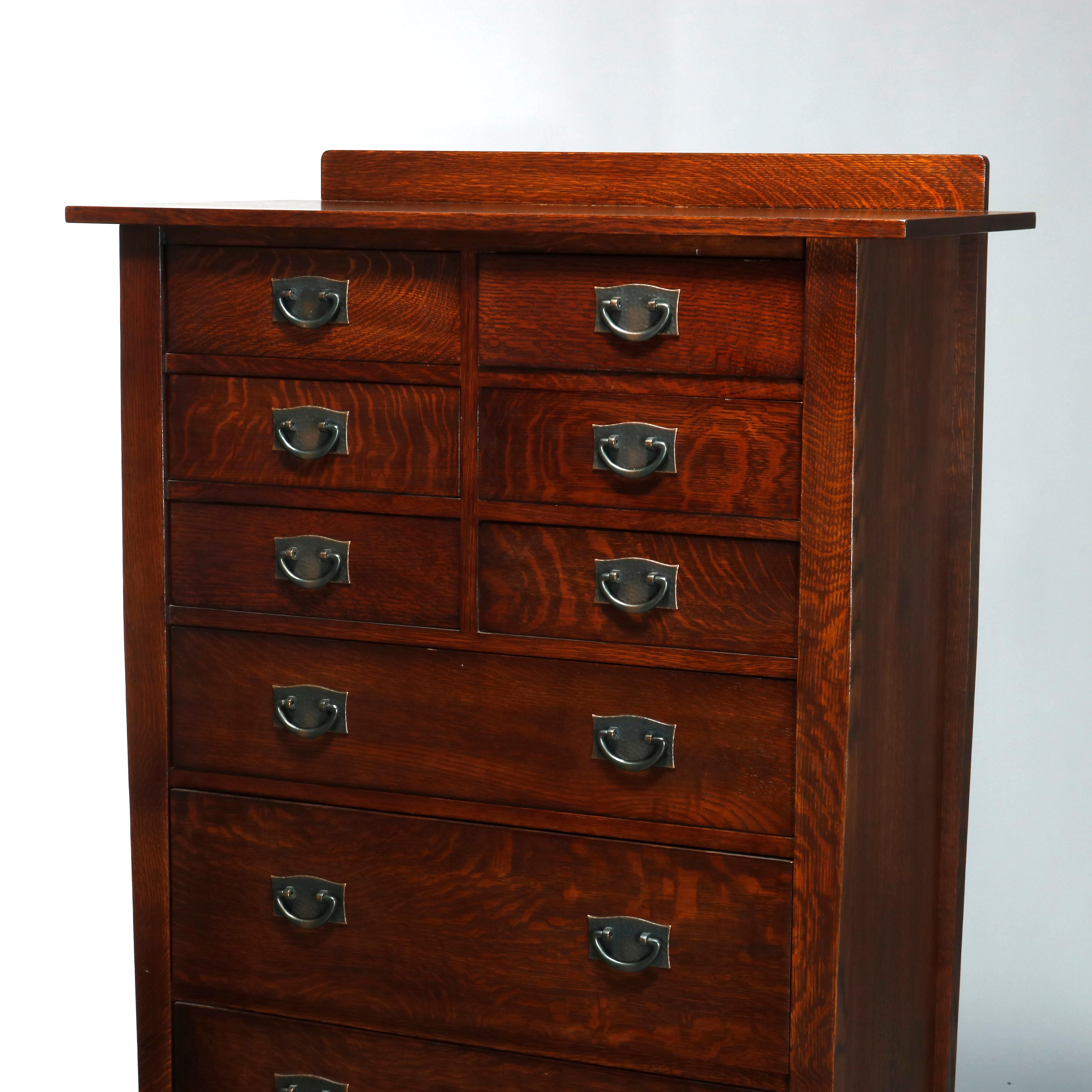 An antique Arts & Crafts mission high chest of drawers by Stickley after Harvey Ellis offers quarter sawn oak construction with backsplash surmounting six small drawers over three graduated long drawers, raised on straight and square legs and having