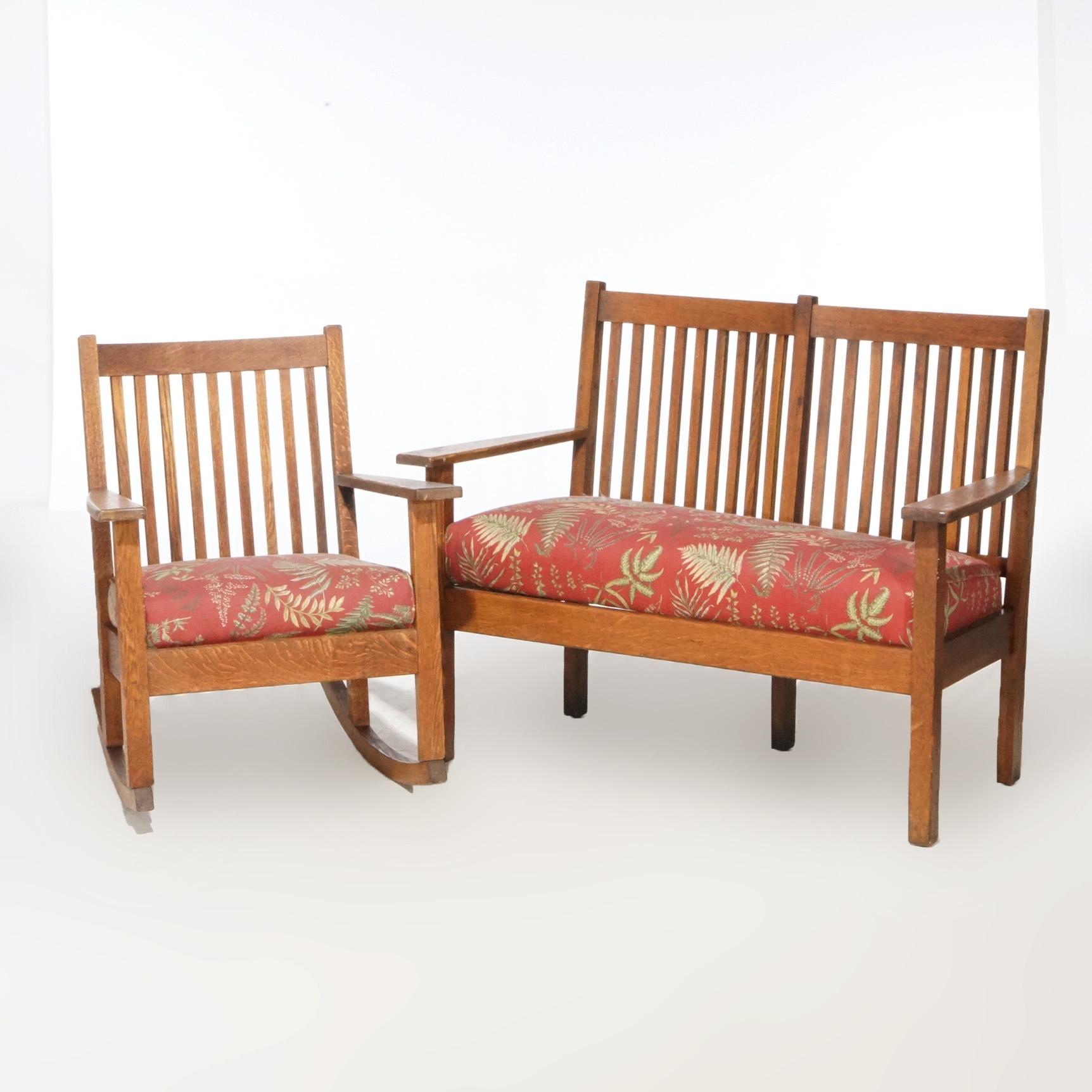 An Arts and Crafts Mission seating set in the manner of Stickley Bros. offers oak construction with spindle backs and upholstered seats; set includes rocking chair and settle; 20th century

Measures - Settle 35.25