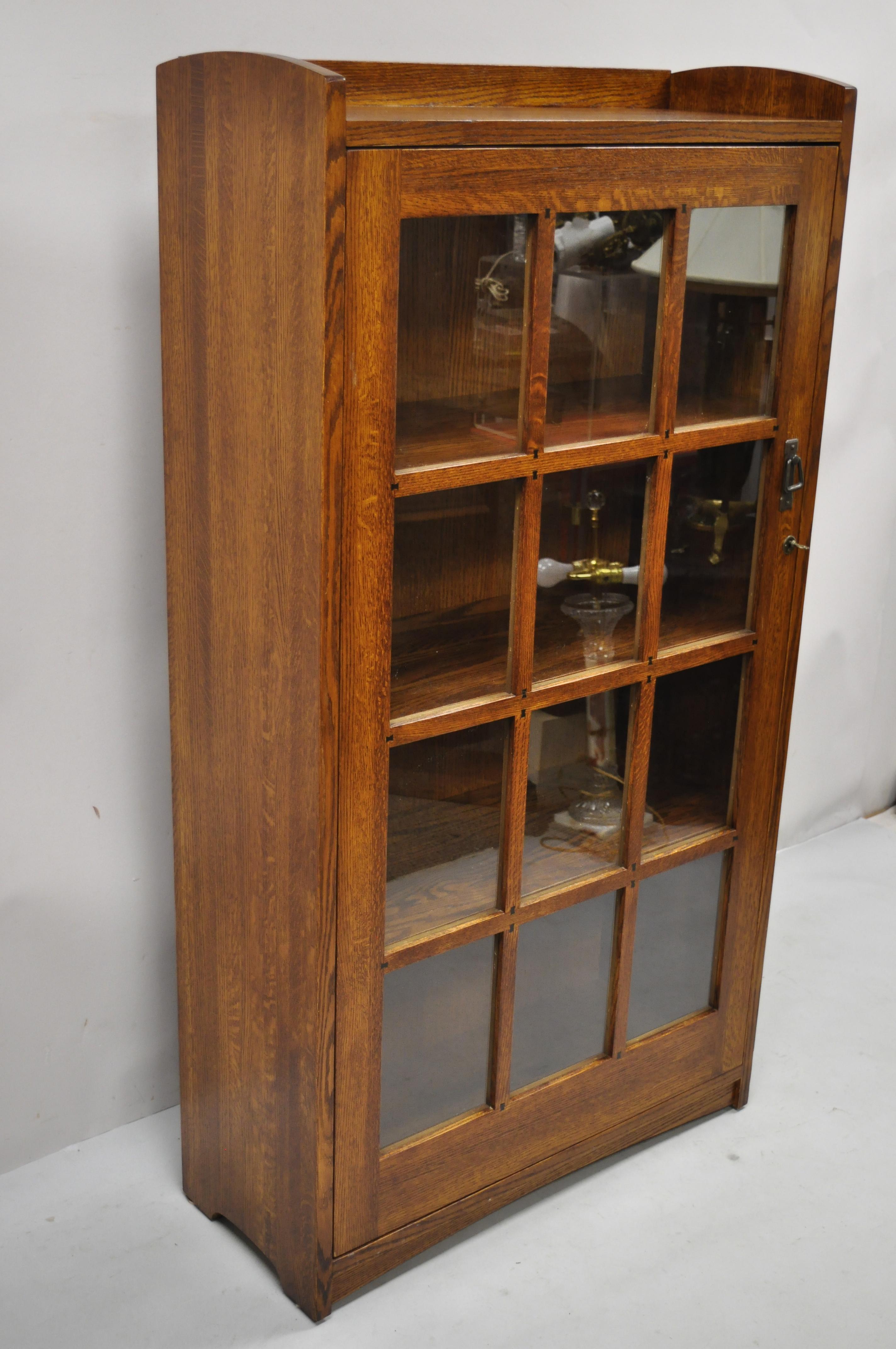 Mission oak style Arts & Crafts one door oak wood china cabinet curio bookcase. Item features solid wood construction, beautiful wood grain, 1 glass swing doors, working lock and key, 3 wooden shelves, quality craftsmanship, great style and form.