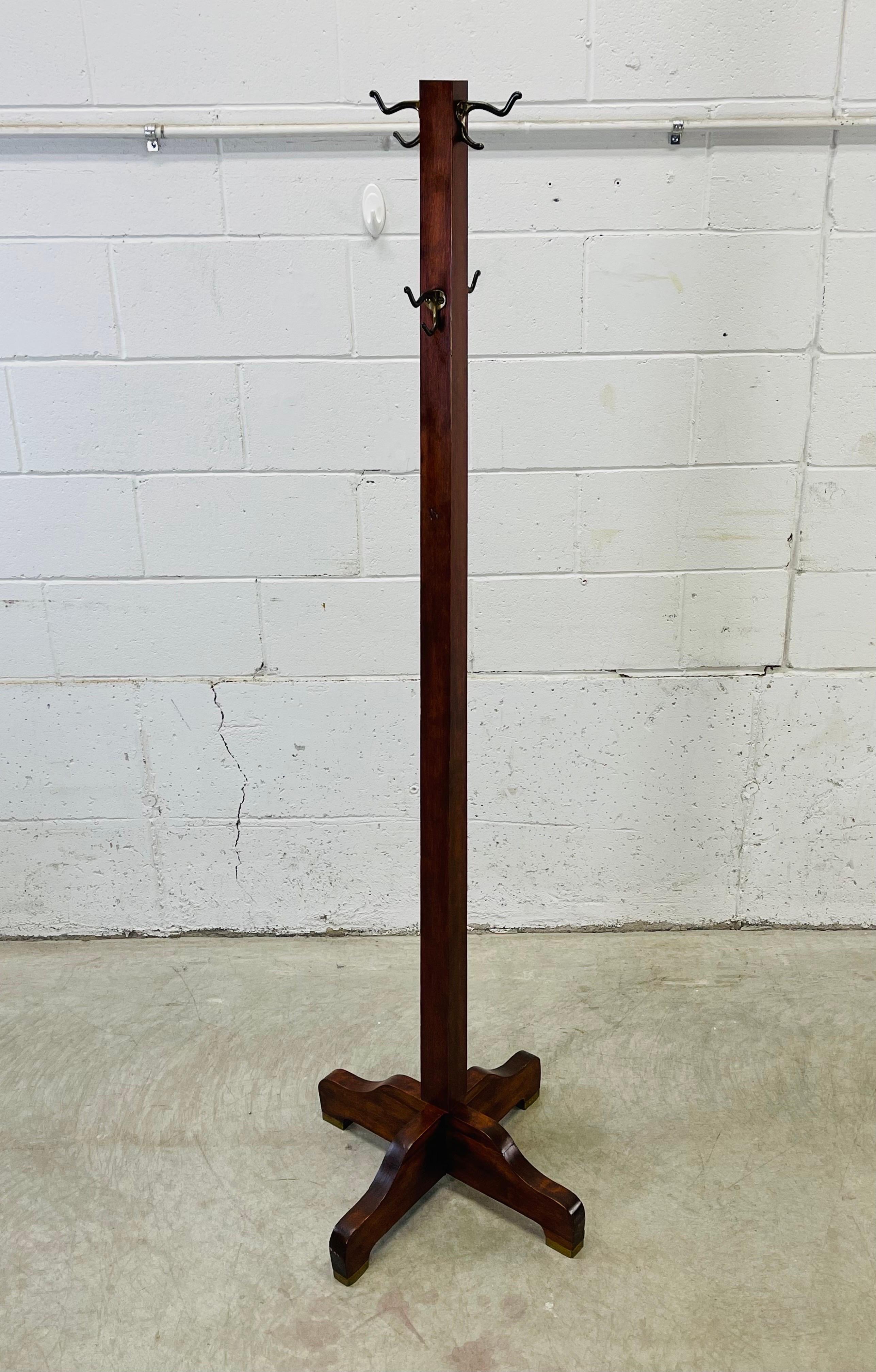Vintage 1930s Mission Oak style coat rack with brass accented feet. The coat rack has four hooks and is sturdy. Marked underneath Sikes Furniture.
