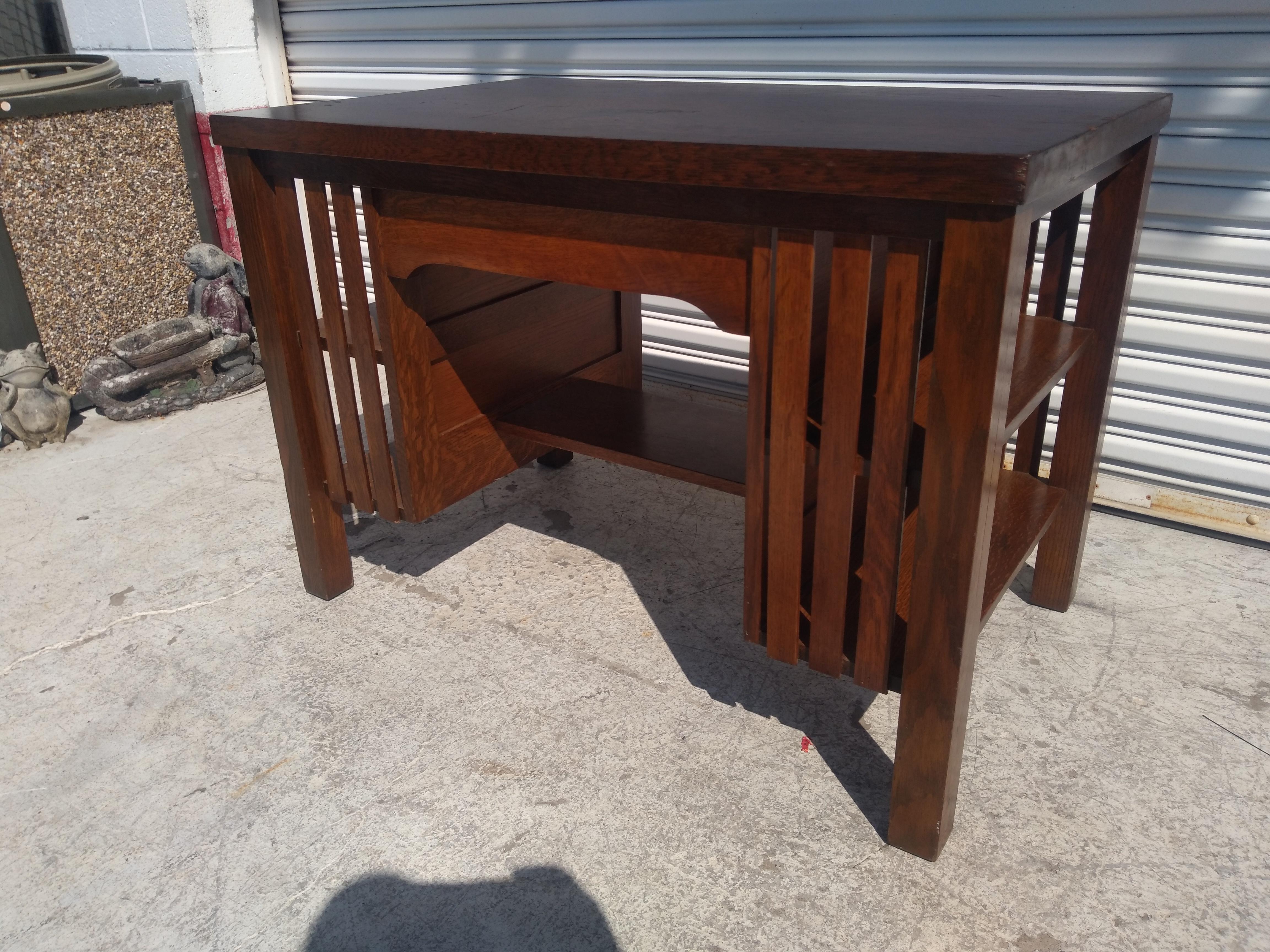 This is a nice example of Arts and Crafts craftsmanship. This Mission Oak desk is made of oak and quarter sawn oak. It has a single drawer for storage and bookshelves built-in on both sides. The front and back have slats covering the bookshelves.