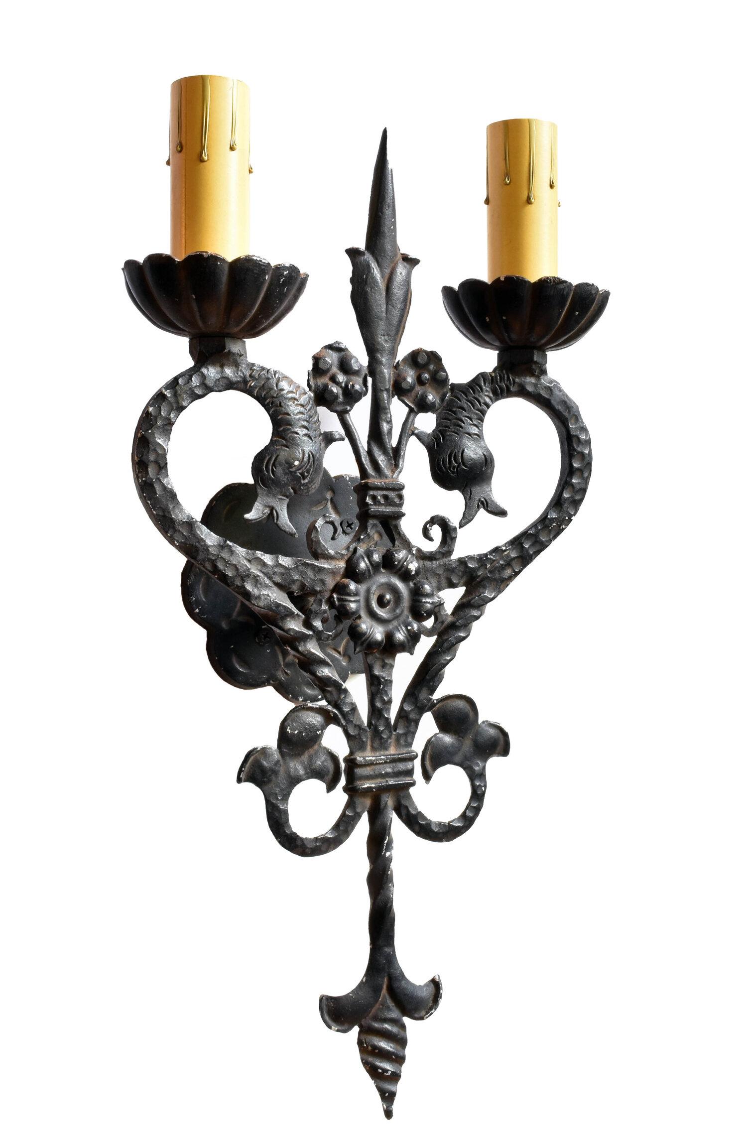Intricate Mission Revival sconces featuring two feathered serpents. Petaled bobeche’s and sharp floral elements are present throughout these hammered and twisted aluminium sconces. 
Stamped on the back “CARLTON FDRY #600”

Illumination: 2