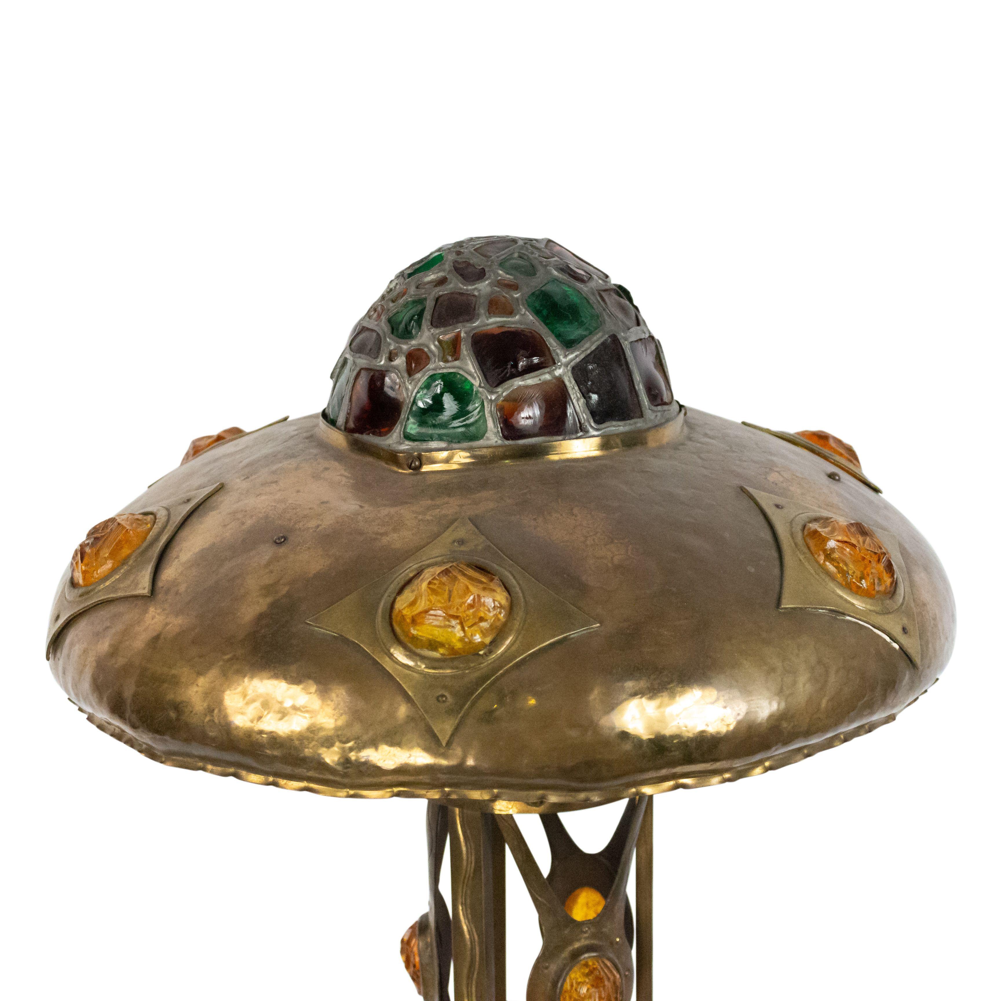 Mission-style hammered brass table lamp with multi-colored slag glass on shade and base.
