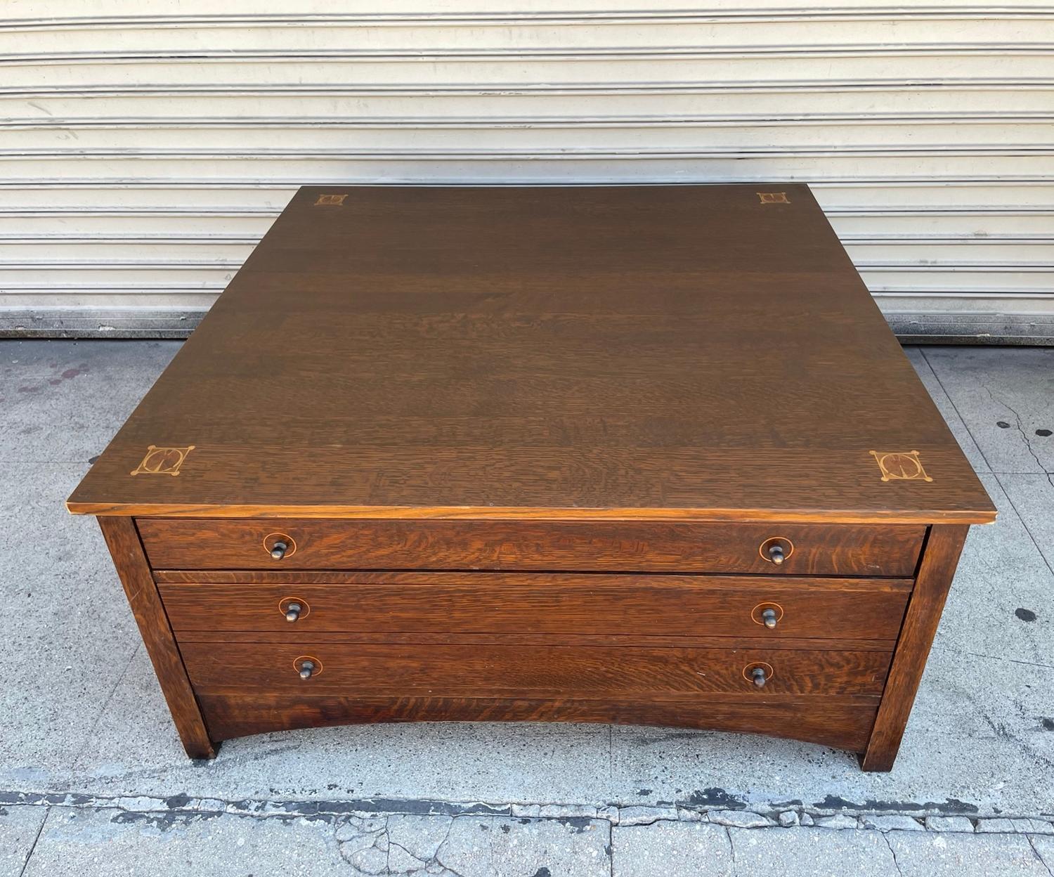 Mission style coffee table by Stickley.

One shallow drawer and one deep, double drawer on each side for a total of four drawers.

Made in solid oak.

Measurements:
40 inches square x 19 inches high.