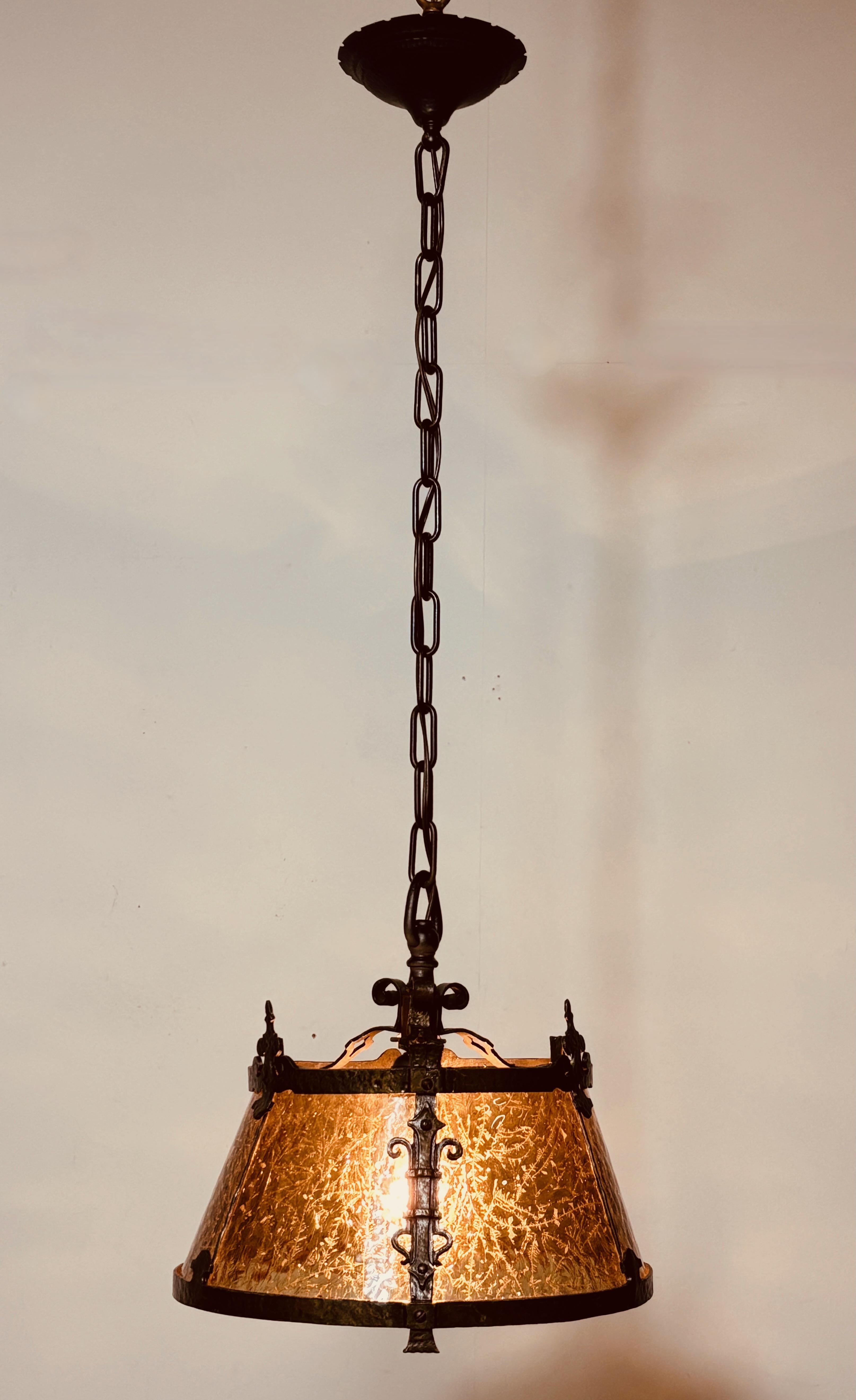 Mission / Arts and Crafts style hanging light fixture.
Wrought iron, metal and heavily textured amber color glass.
Recently re-wired and ready to install. In excellent condition.
We can shorten the length to the buyer's specifications if desired.