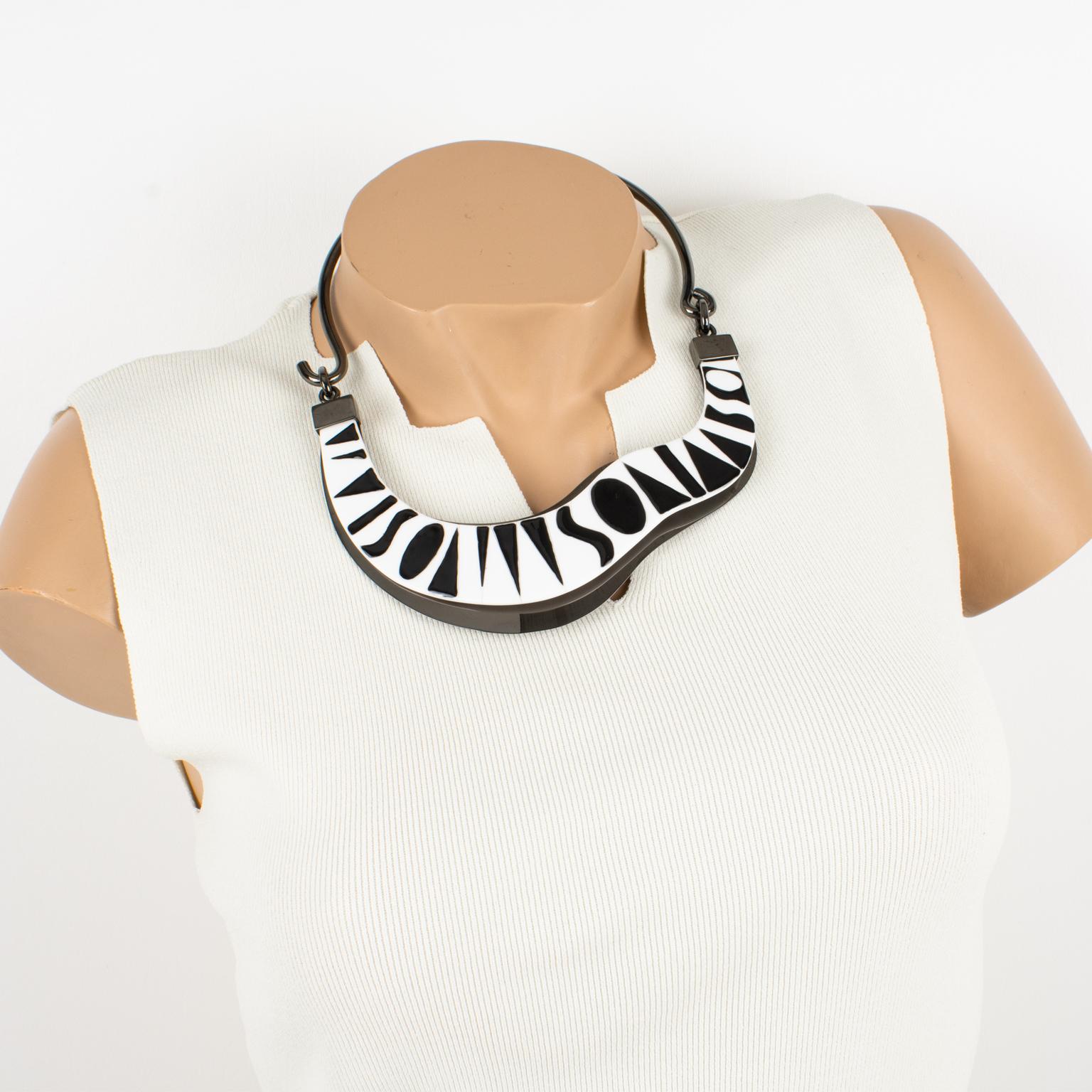 Missoni Italia creó este increíble collar gargantilla de alta costura para su desfile prêt-à-porter de primavera de 2014. La pieza presenta una forma asimétrica, construida con una banda rígida de bronce de cañón, complementada con una banda de