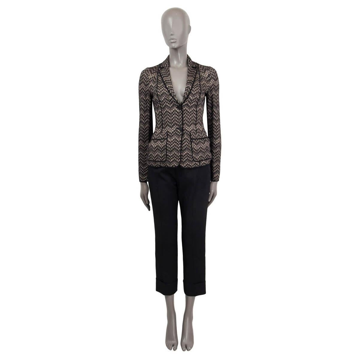 100% authentic Missoni zig zag soft knit blazer in black and taupe wool (60%) and rayon (40%). Features long sleeves and sewn shut patch pockets on the front. Opens with two buttons on the front. Unlined. Has been worn and is in excellent