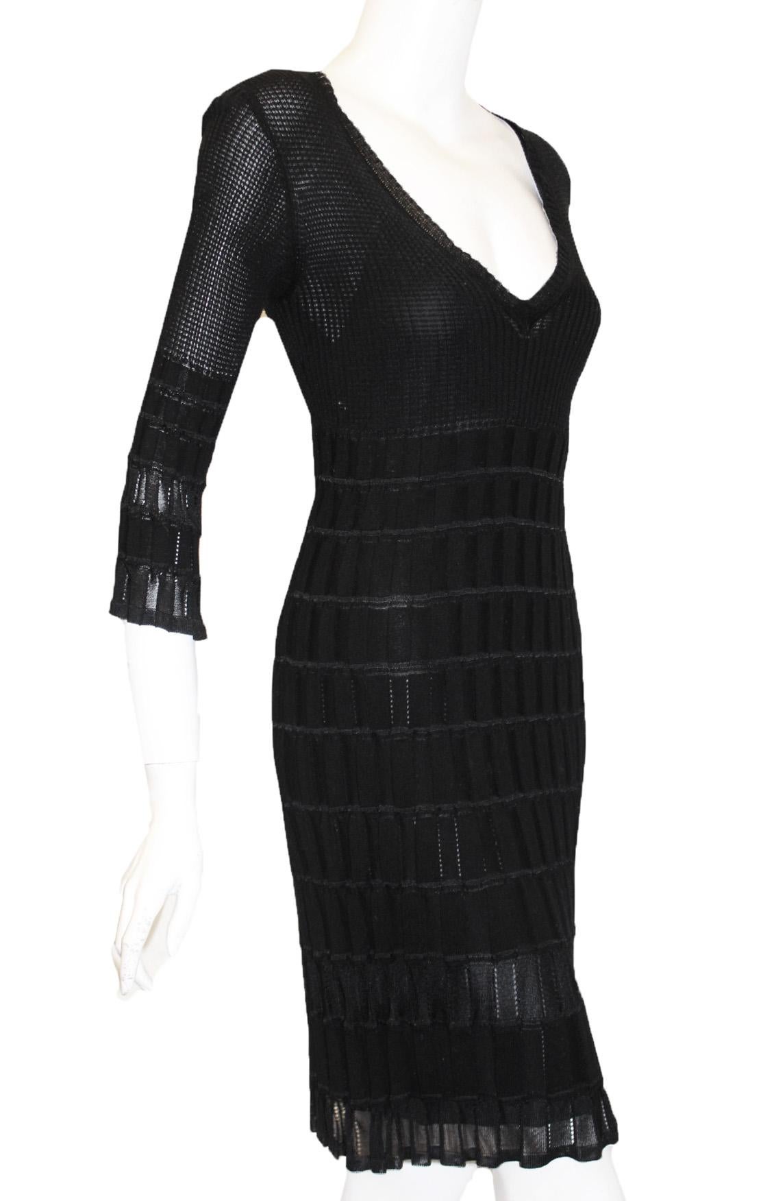 Missoni black 3/4 sleeve knit dress includes a low cut V neck.  The skirt of this dress is more textured cable knit with box pleat design.  This  solid color dress is composed of a stretchy knit fabric and has some give for the wearer.  The dress