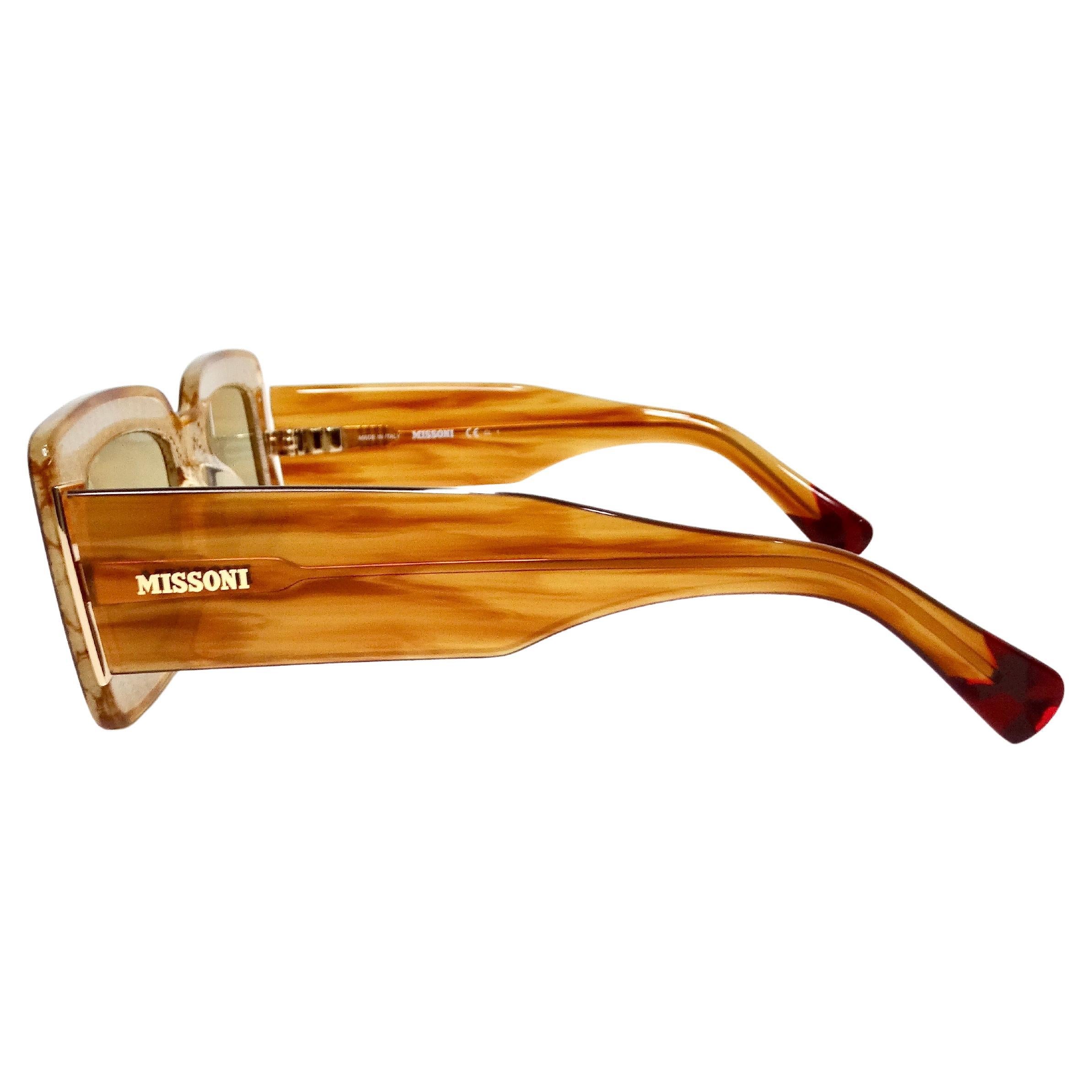 Gli occhiali da sole quadrati in acetato marrone di Missoni con l'iconico dettaglio della maglia sono un accessorio di lusso che combina perfettamente un design audace con una lavorazione sofisticata. Realizzati in acetato marrone in una classica