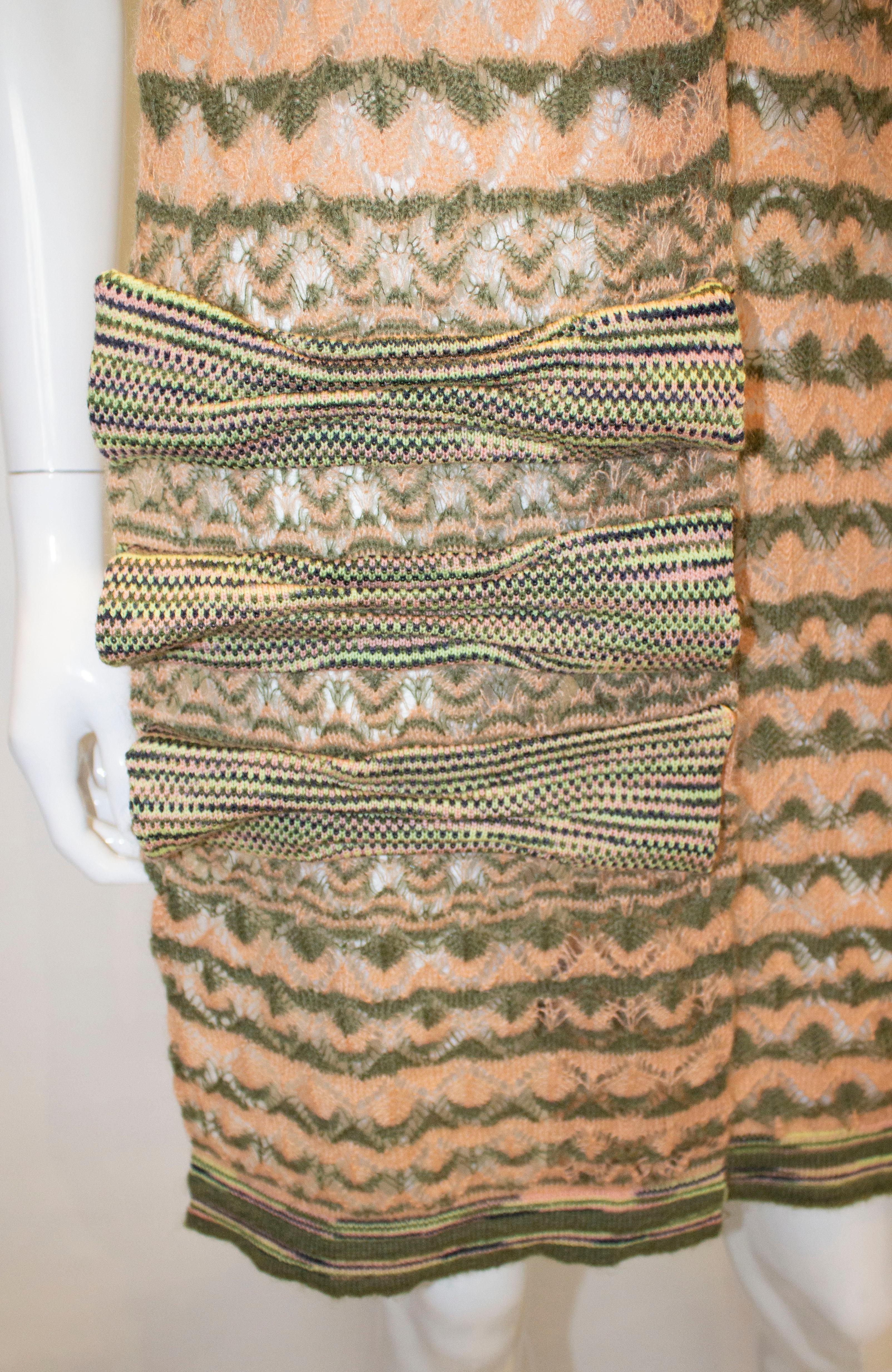 Un super foulard pour le printemps  par Missoni, étiquette brune. Dans un mélange de mohair, de laine et de nylon, l'écharpe est d'un joli vert avocat avec du pêche, du bleu et du marron et comporte trois nœuds à une extrémité. Mesures : largeur