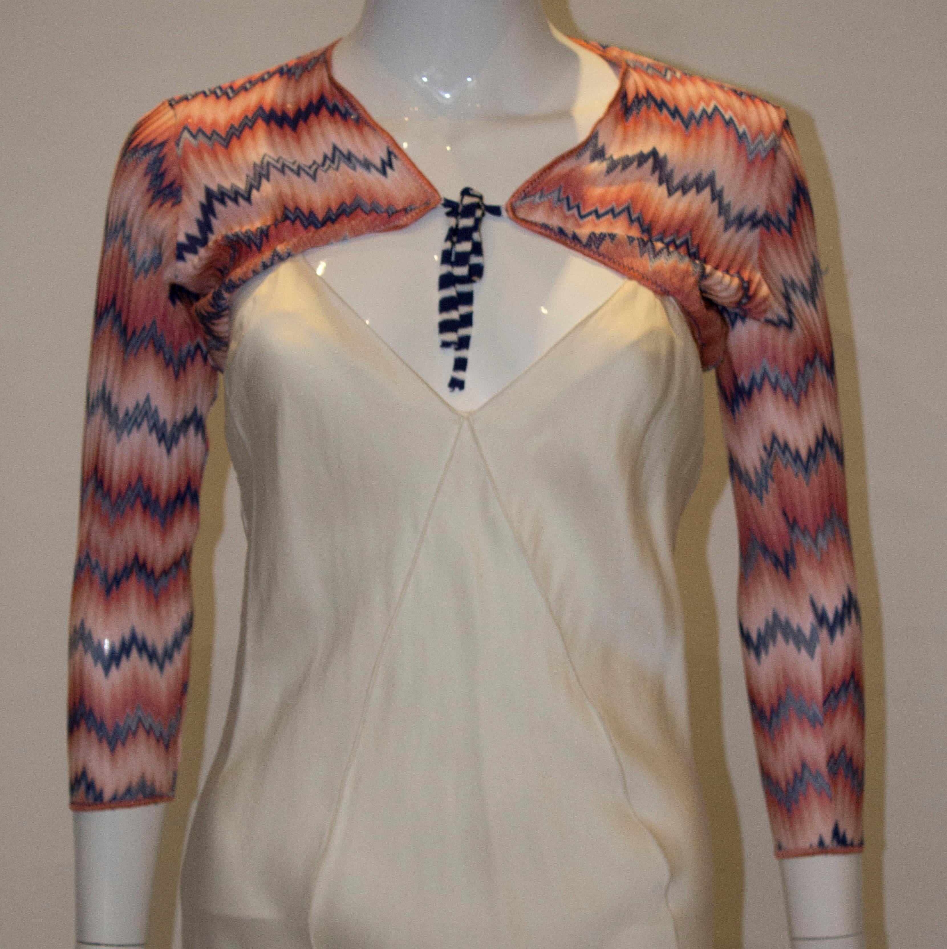 A pretty shrug by Missoni, brown label. The shrug is in a mix of peach, blue and white  with blue and white stripe ties.