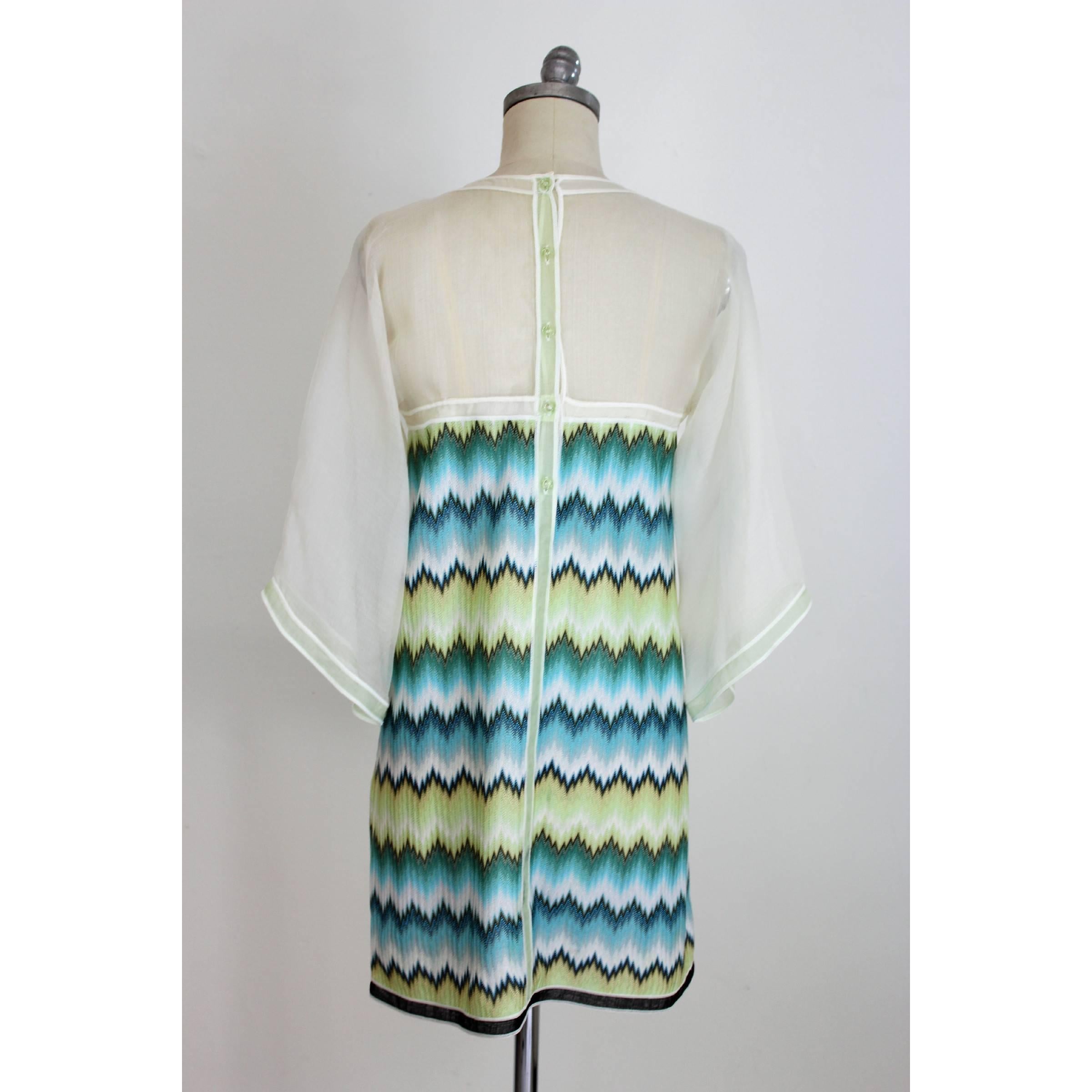 Missoni ceremony dress, white, blue and green, 53% silk 47% viscose. Soft 3/4 transparent sleeve, the dress has the typical Missoni geometric designs with shades ranging from green to light blue. Made in Italy. Excellent vintage conditions.

Size 44
