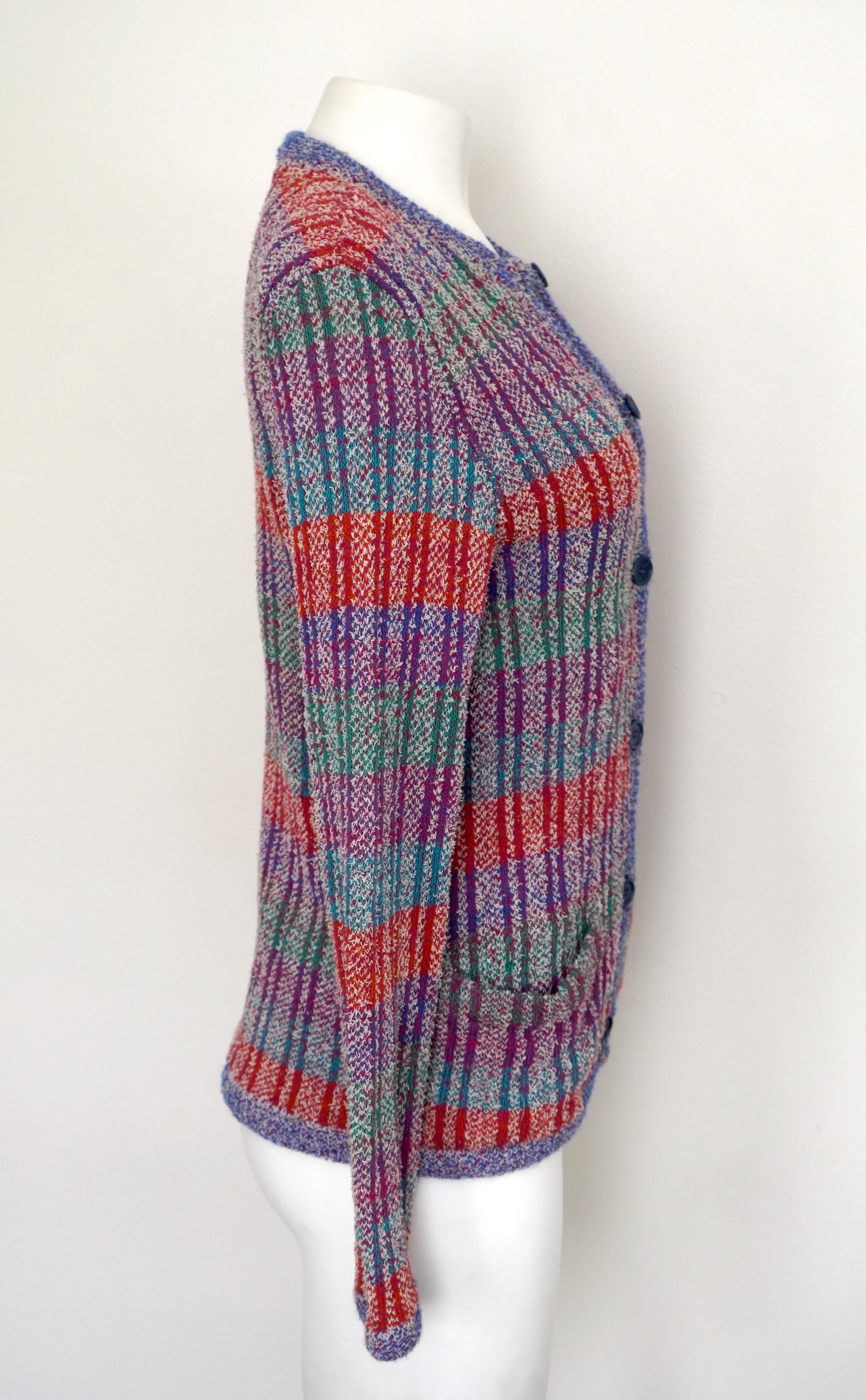 This colorful Missoni cardigan sweater is in great condition. It has a 6 blue button closure, with 2 front pockets. 
It is made of cotton, wool, linen, & nylon, in the colors: royal blue, light blue, purple, green, red, and white. There is no