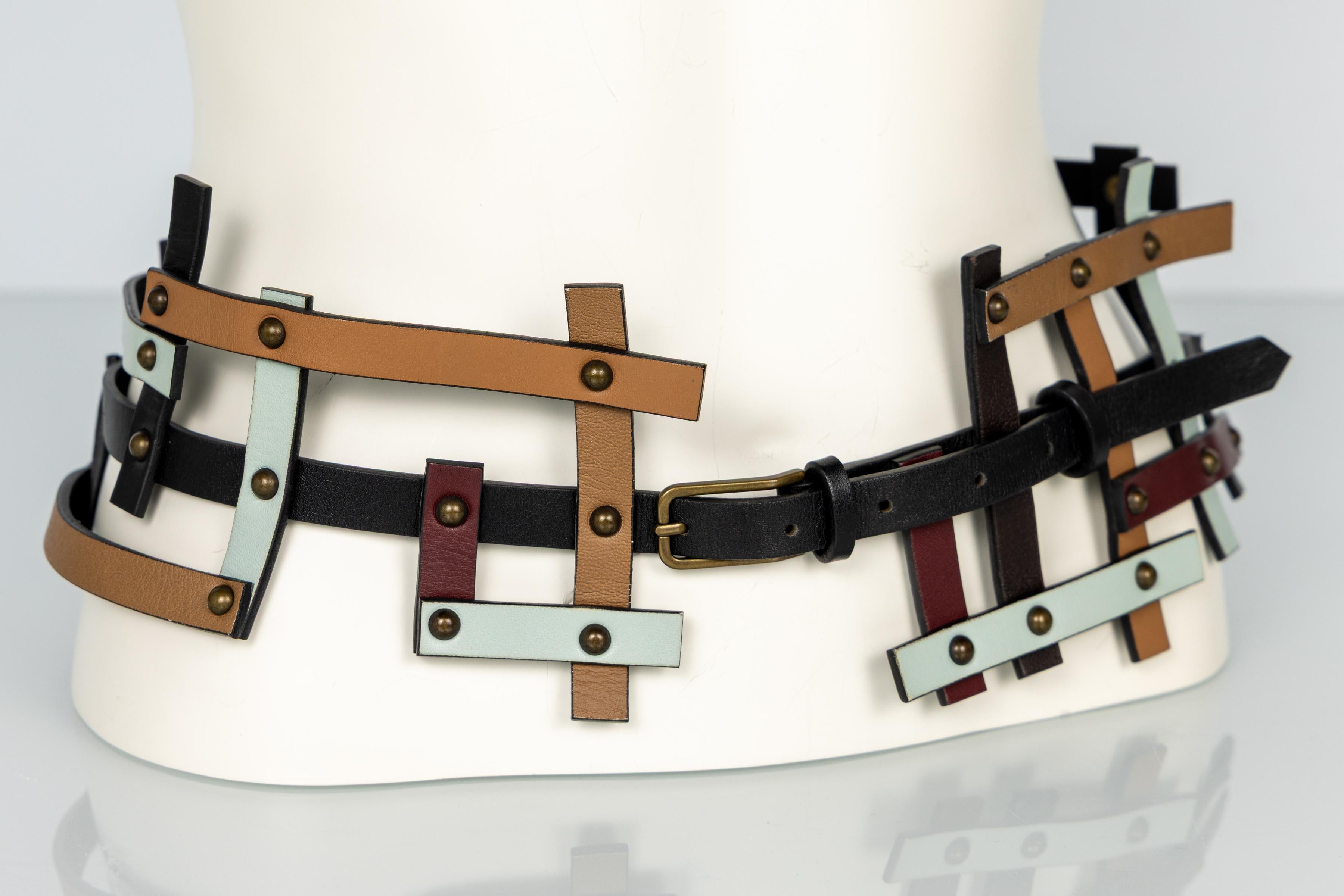 Dalla collezione Missoni Autunno 2007, questa eccezionale cintura esemplifica l'artigianato sperimentale e la sensibilità modernista del marchio. Realizzata con strisce di pelle multicolore che si intersecano tra loro nei colori nero, marrone,