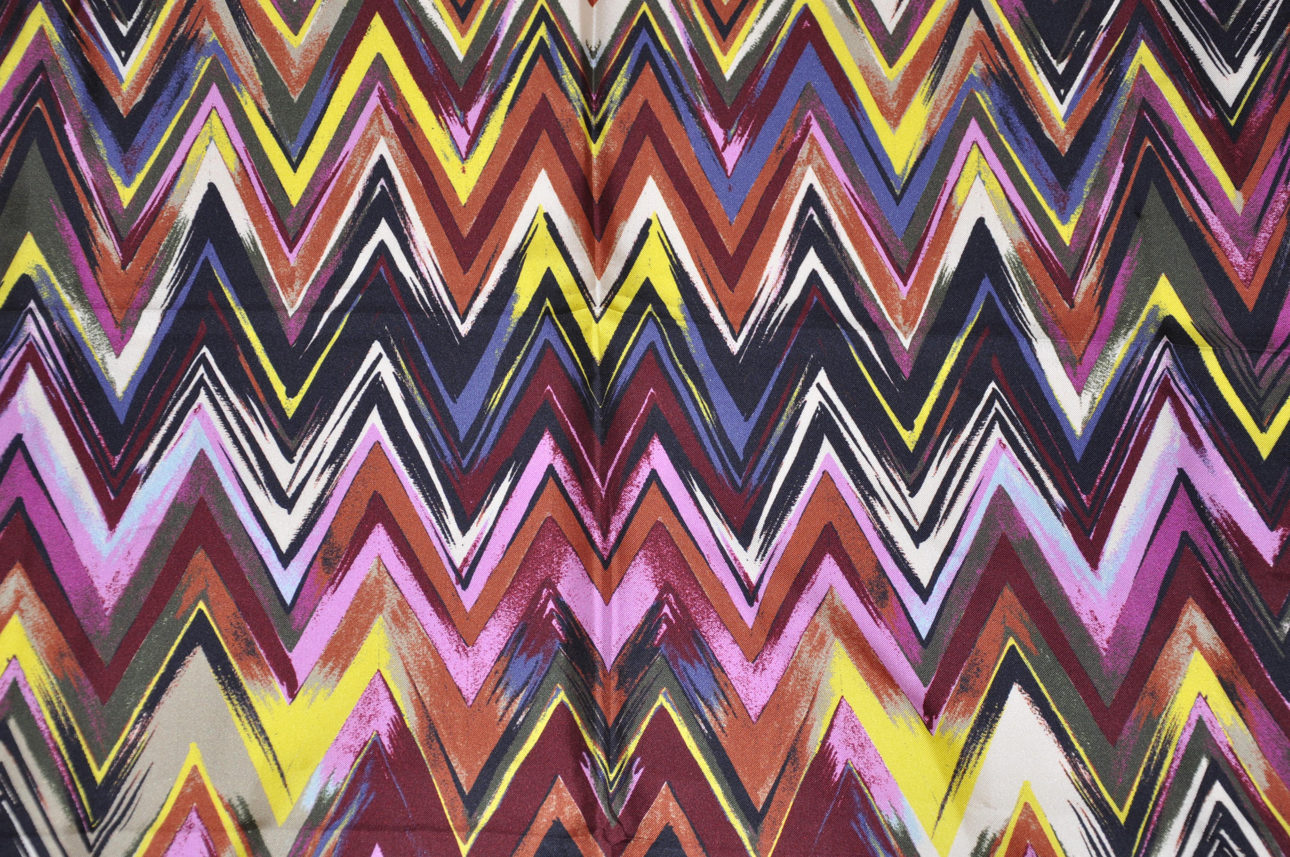        L'écharpe en soie ZigZag multicolore, signature emblématique de Missoni, merveilleusement détaillée et finie avec des bords roulés à la main, mesure 35 pouces par 36 pouces. Fabriquées en Italie.
